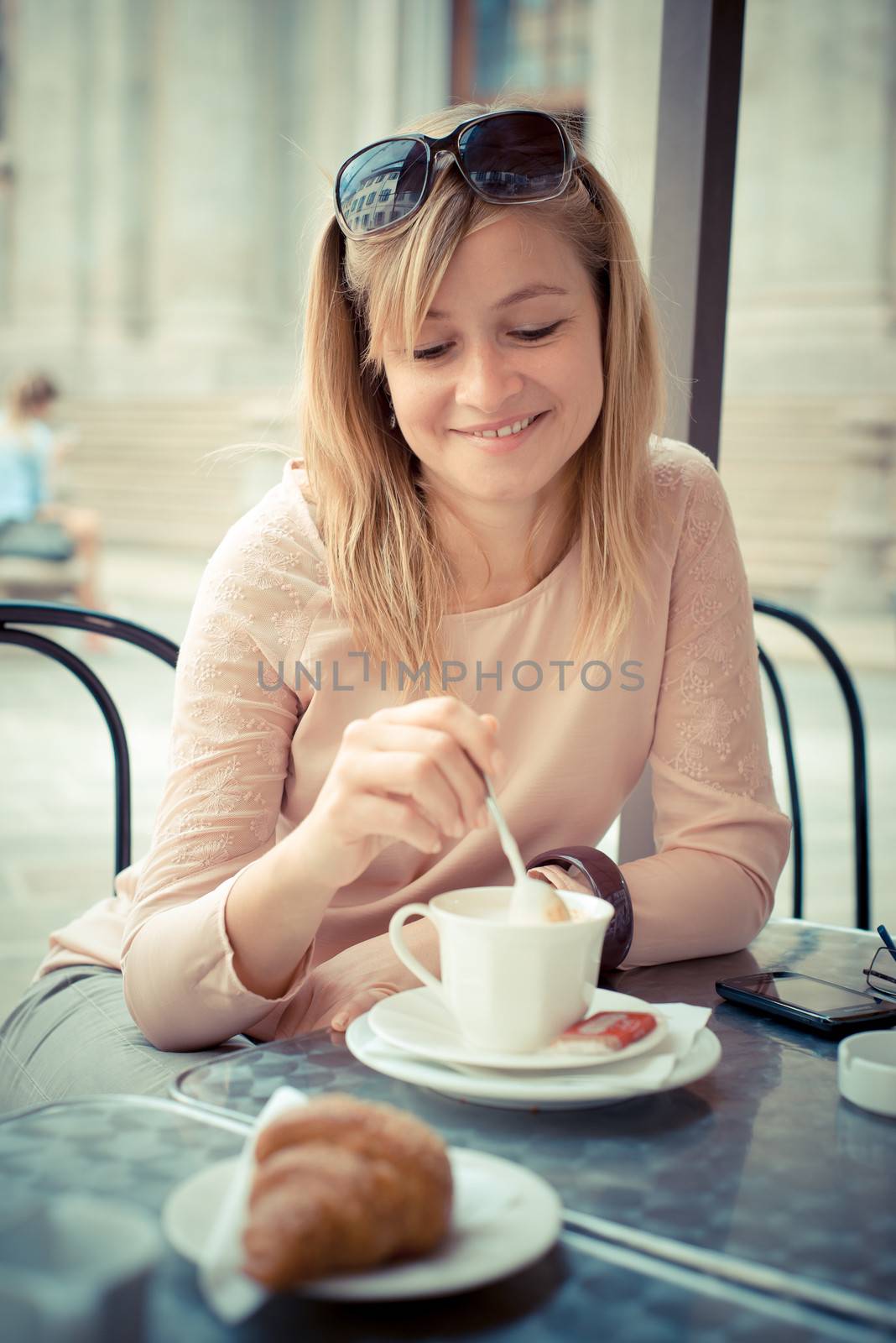 beautiful blonde woman having breakfast at the bar in the city