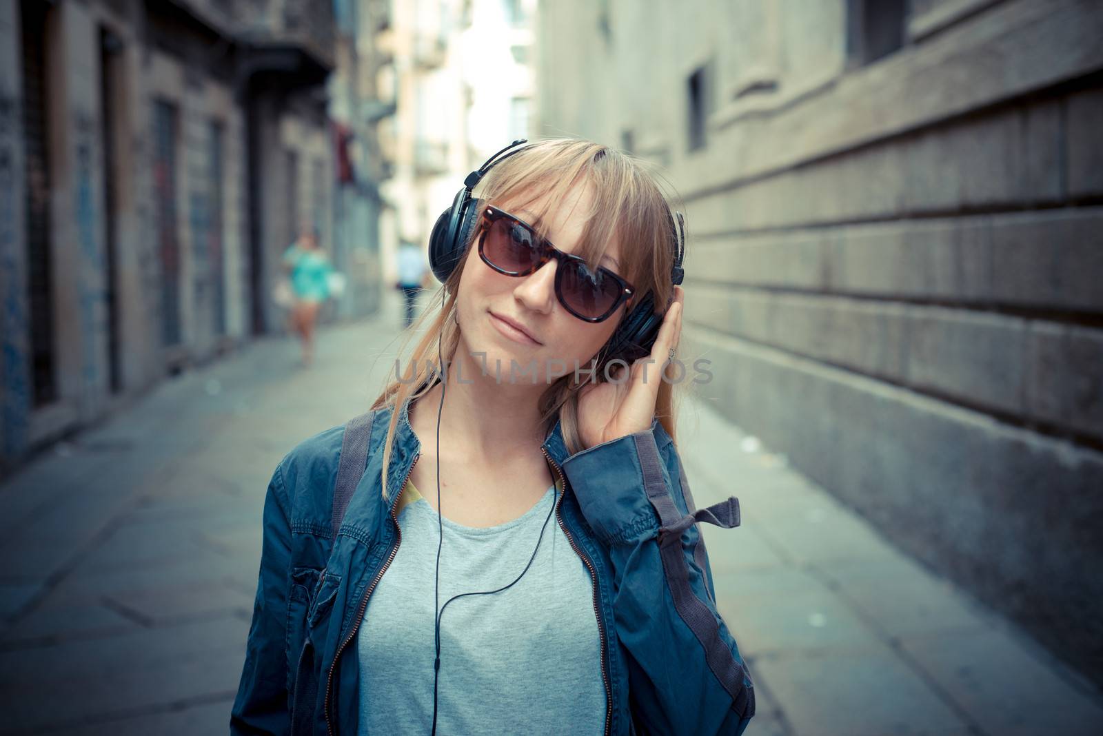 beautiful blonde woman listening to music in the city