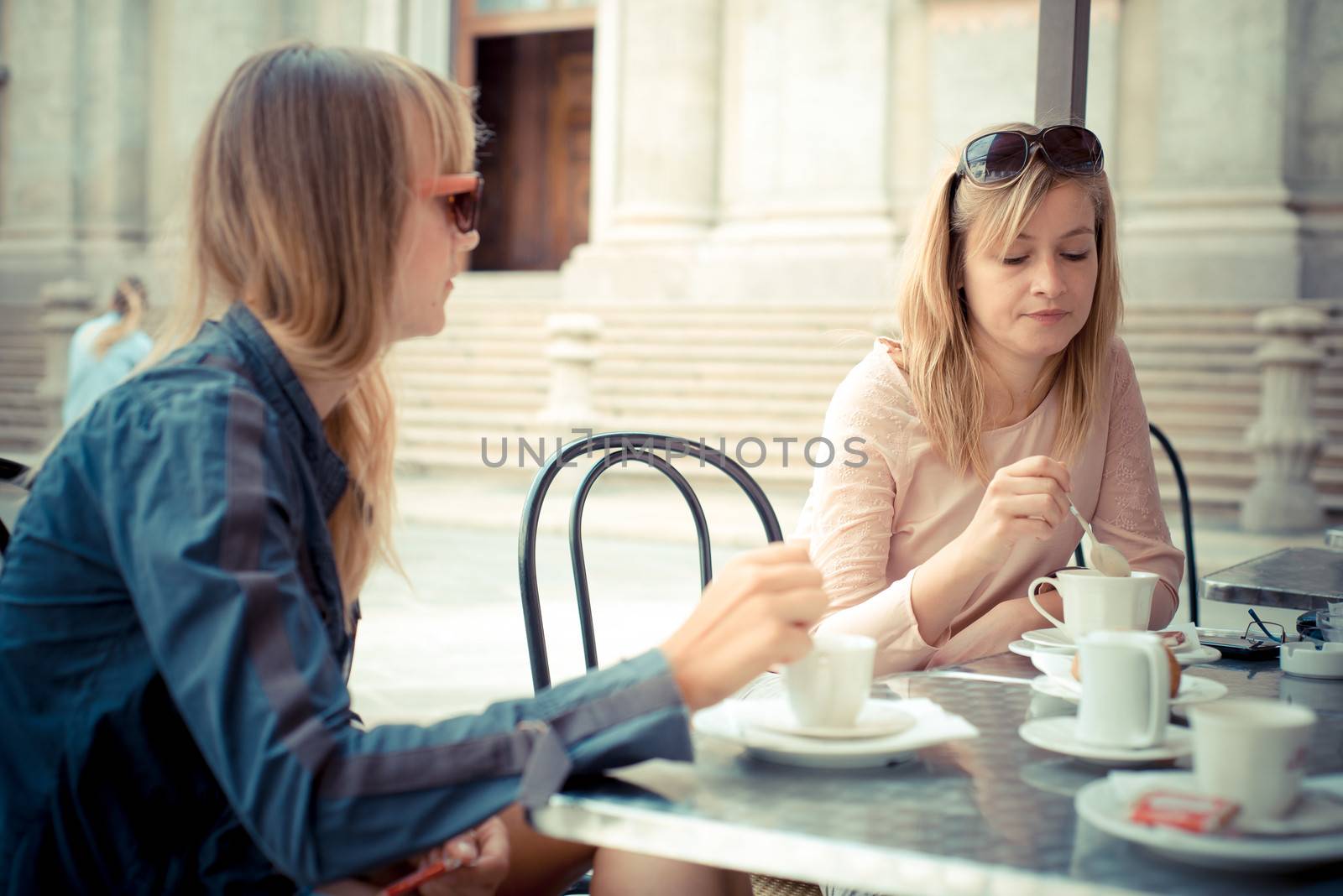 two beautiful blonde women talking at the bar by peus