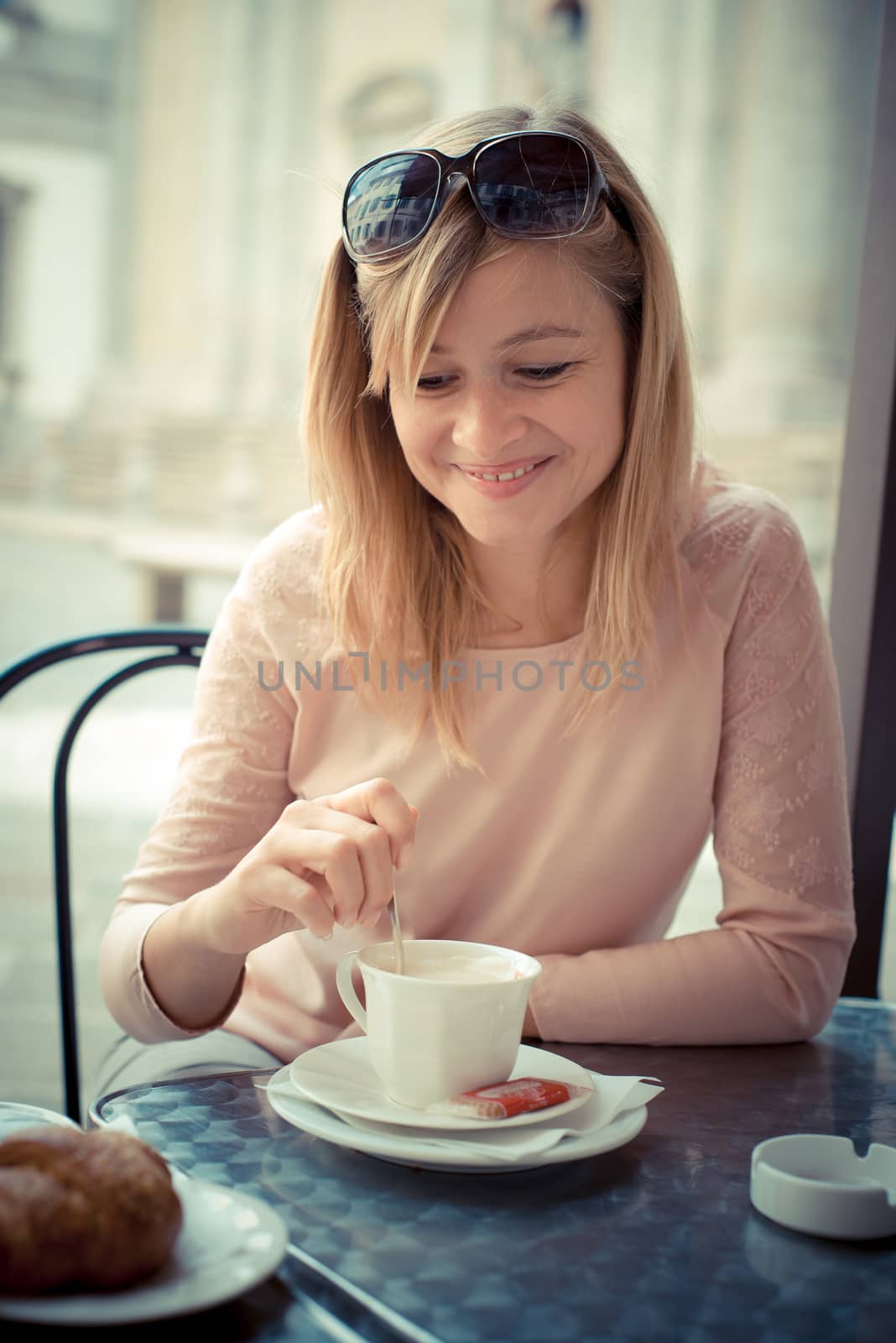 beautiful blonde woman having breakfast at the bar by peus