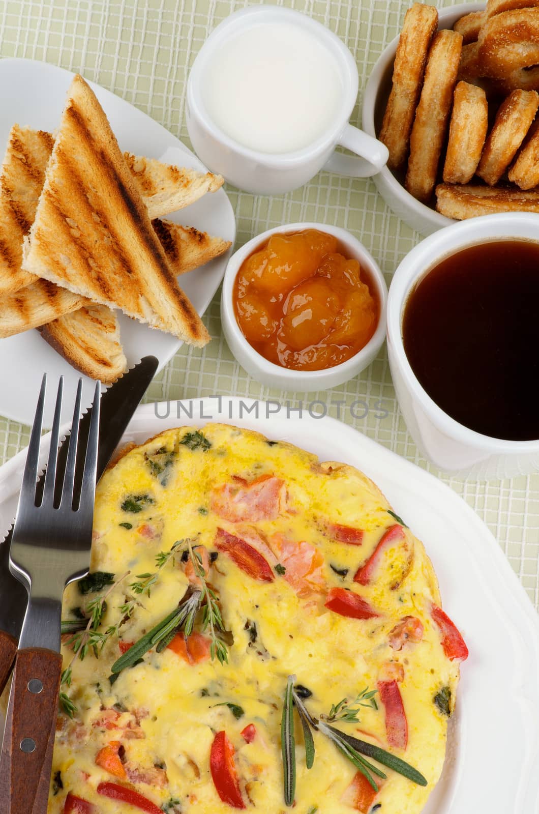 Hearty Breakfast with Delicious Omelet, Toasts, Apricot Jam, Cup of Coffee, Milk and Puff Pastry on light green Checkered background. Top View