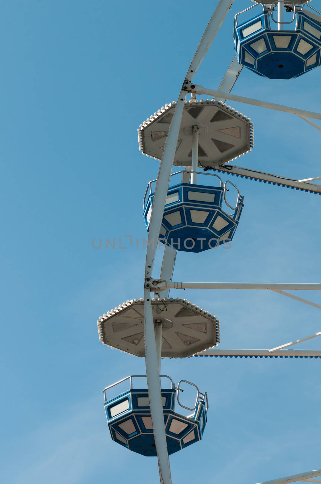 Shot some cabins of ferris wheel over blue sky