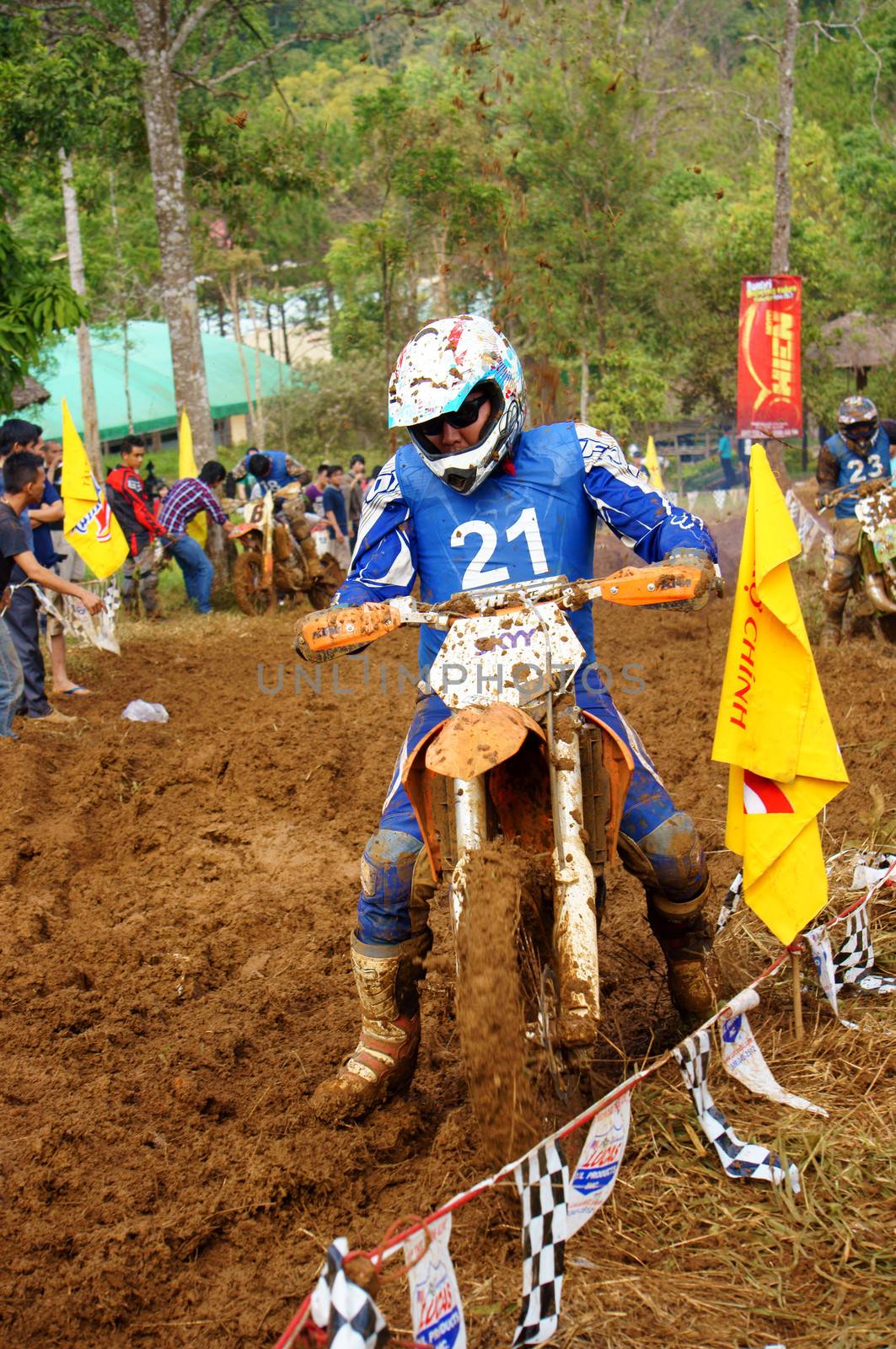 The motorcycle race hole on December at Dambri waterfall, motorcyclist try to speed up goal, red soil way, indistinct dust. December23, 2012