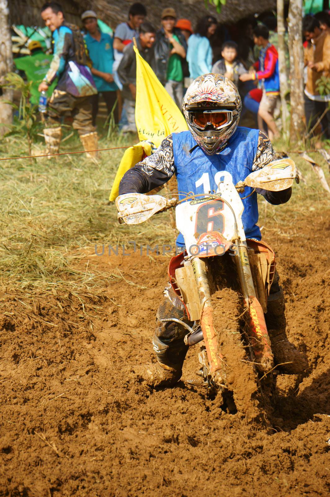 The motorcycle race hole on December at Dambri waterfall, motorcyclist try to speed up goal, red soil way, indistinct dust. December23, 2012