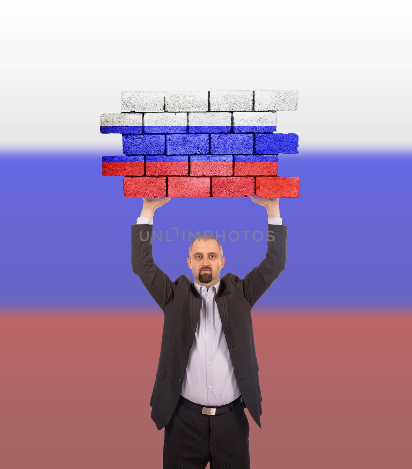 Businessman holding a large piece of a brick wall, flag of Russia, isolated on national flag