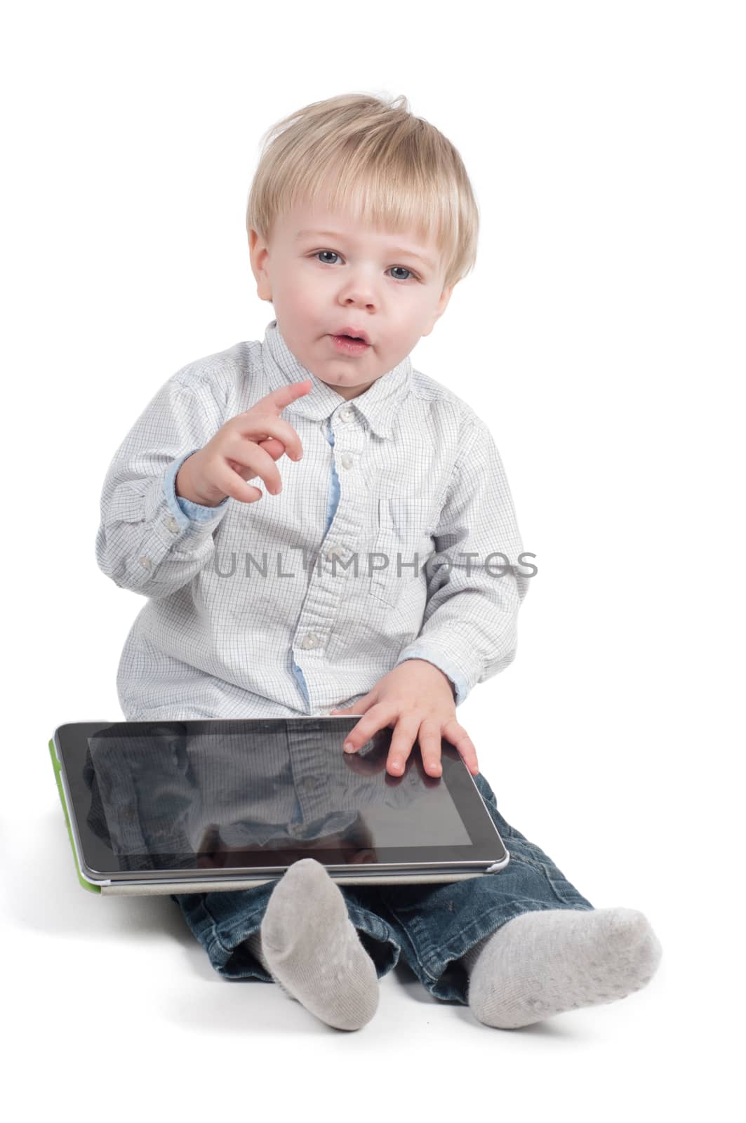 Little cute boy sitting with tablet computer on white background