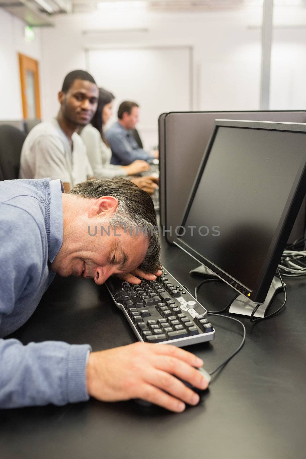 Man taking nap at computer class on the keyboard in college