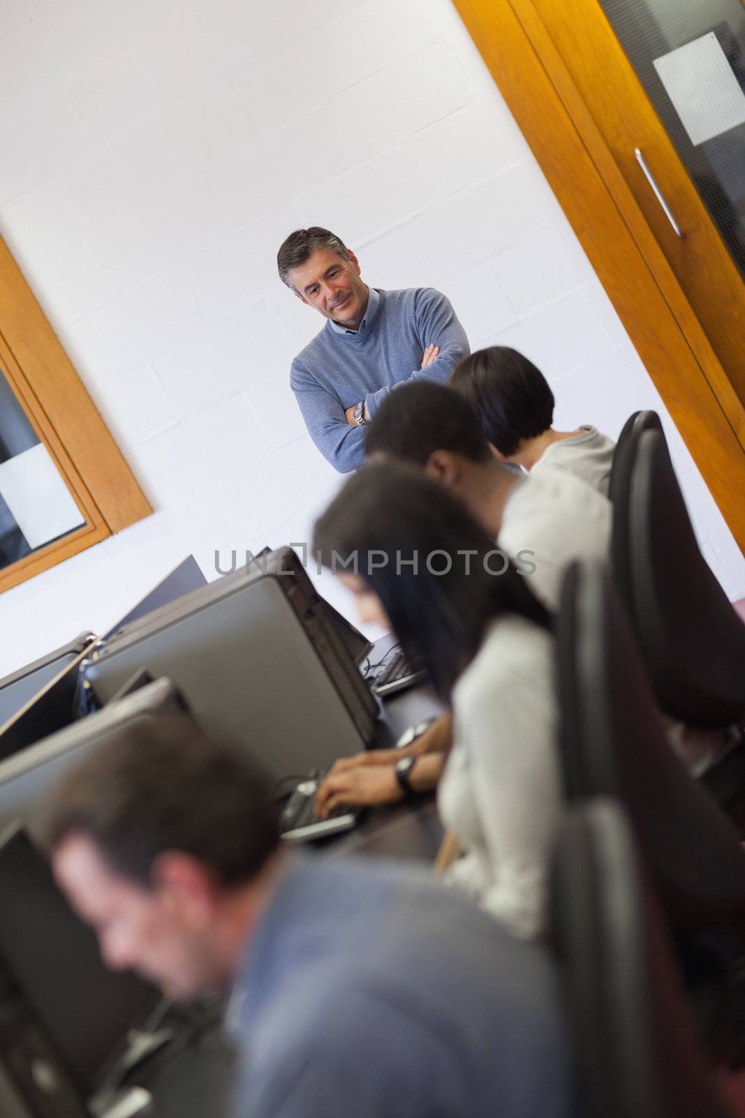 Teacher overlooking students working in computer class