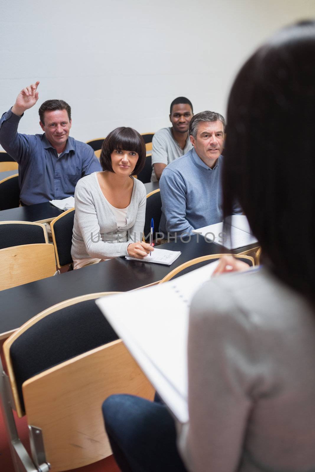 Man asking question in lecture by Wavebreakmedia