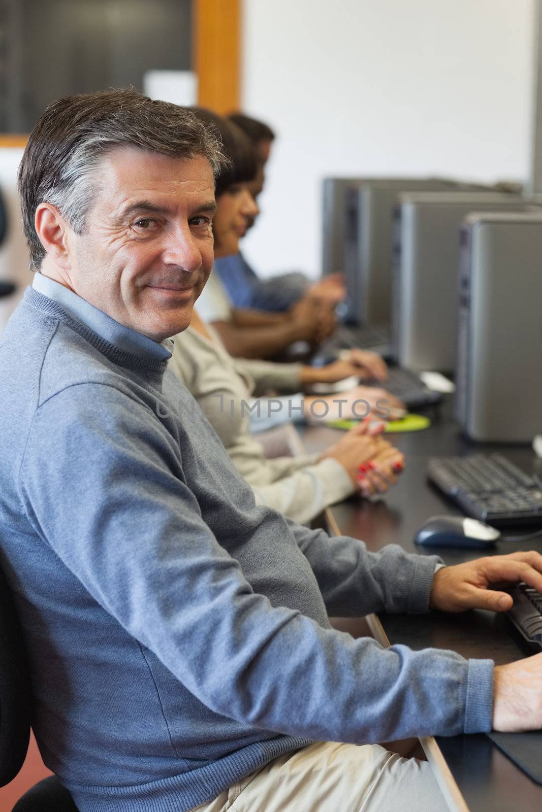 Man sitting at the computer and smiling  by Wavebreakmedia