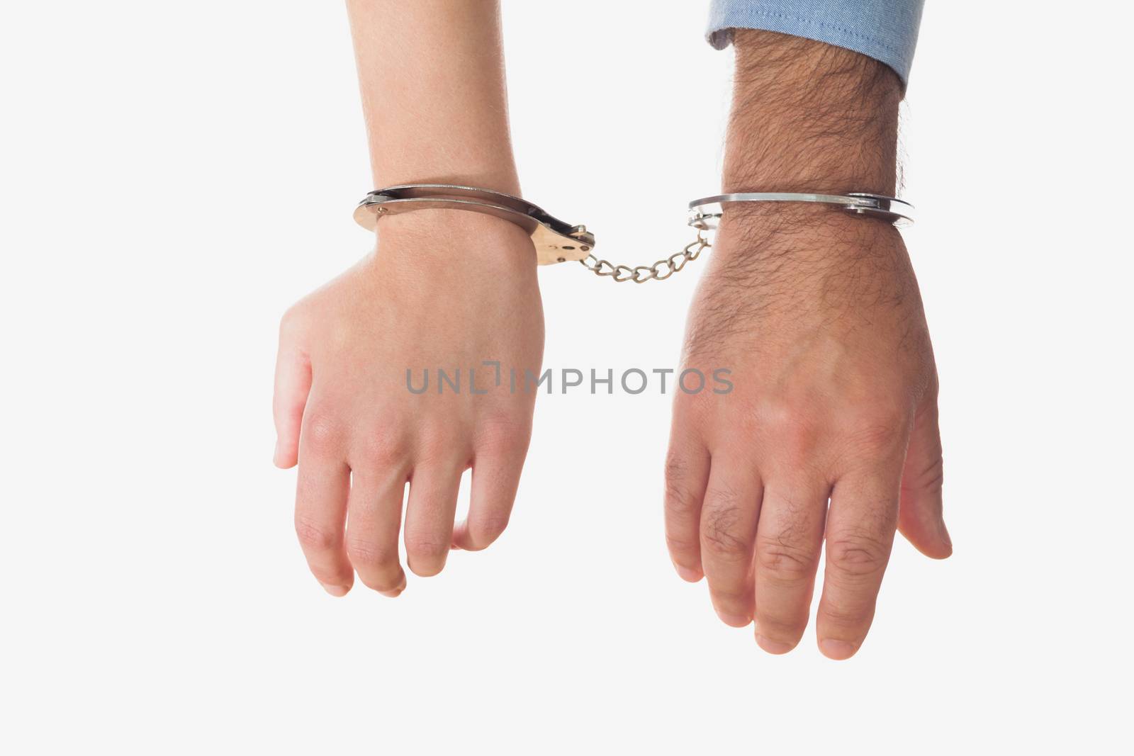 Hands of businessman and business woman in handscuffs over white background