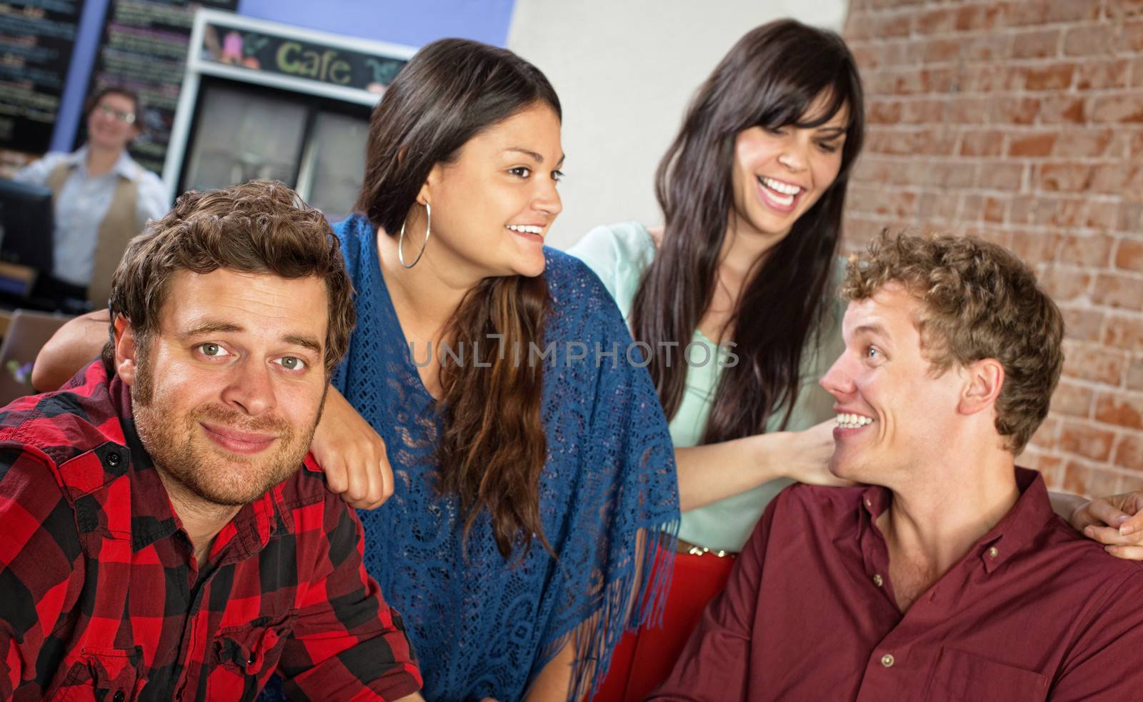 Happy group of cheerful young friends in bistro