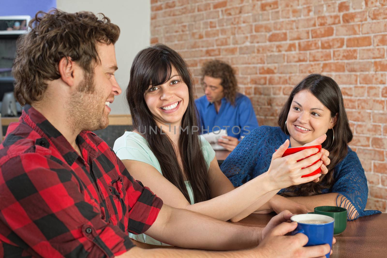 Happy trio sitting inside of a coffee house