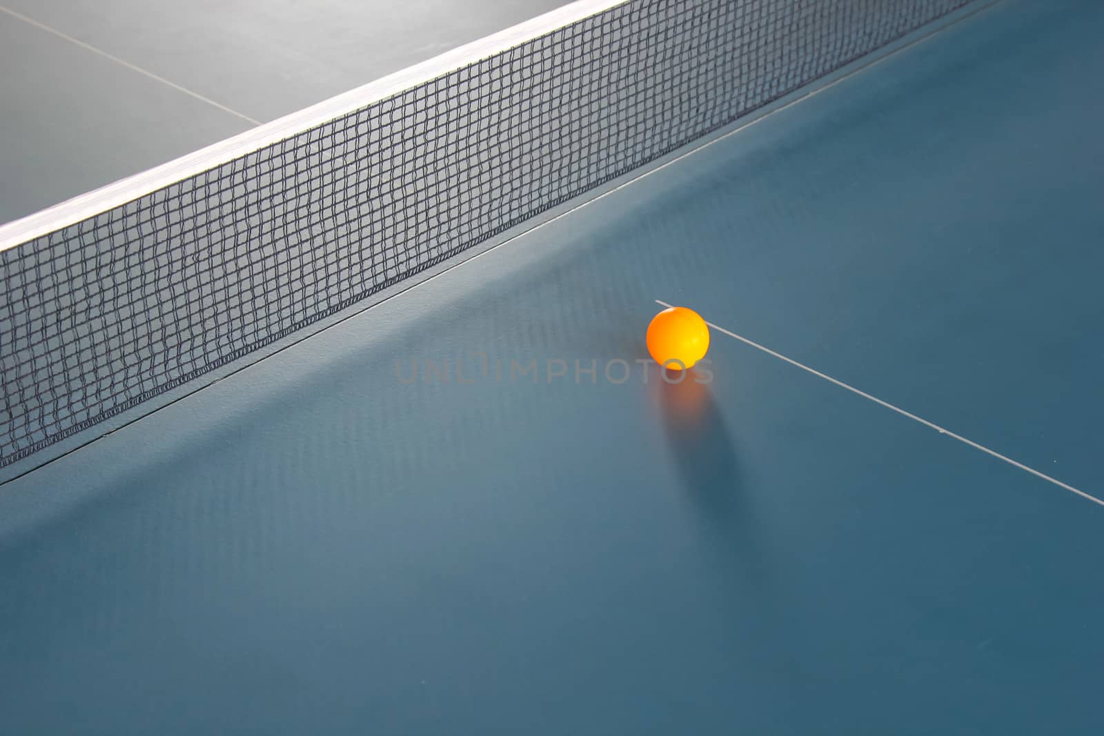 Orange table tennis ball on blue table