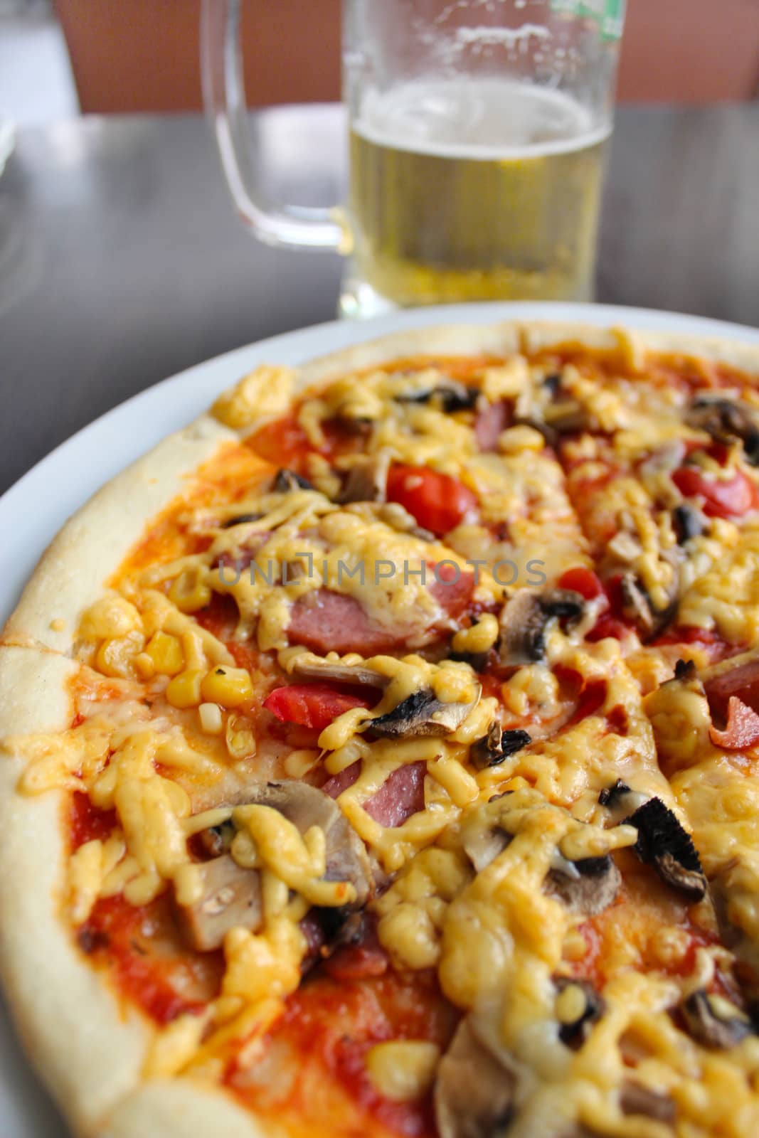 tasty appetizing pizza and glass of beer by alexmak