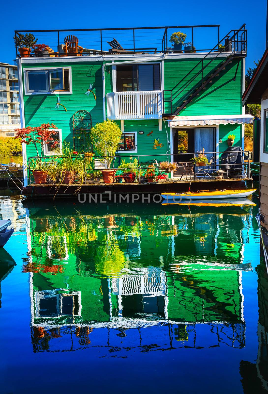 Green Houseboat Floating Home VFisherman's Wharf Reflection Inner Harbor, Victoria Vancouver British Columbia Canada Pacific Northwest.  Close to the center of Victoria, this area has floating homes, boats, piers, and restaurants.