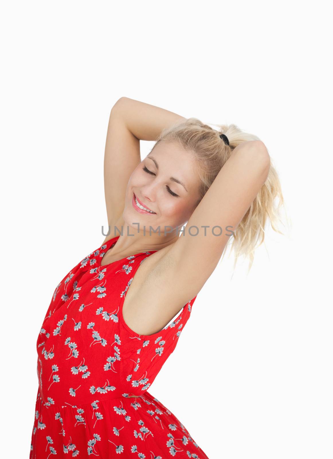 Young woman in red summer dress standing by Wavebreakmedia