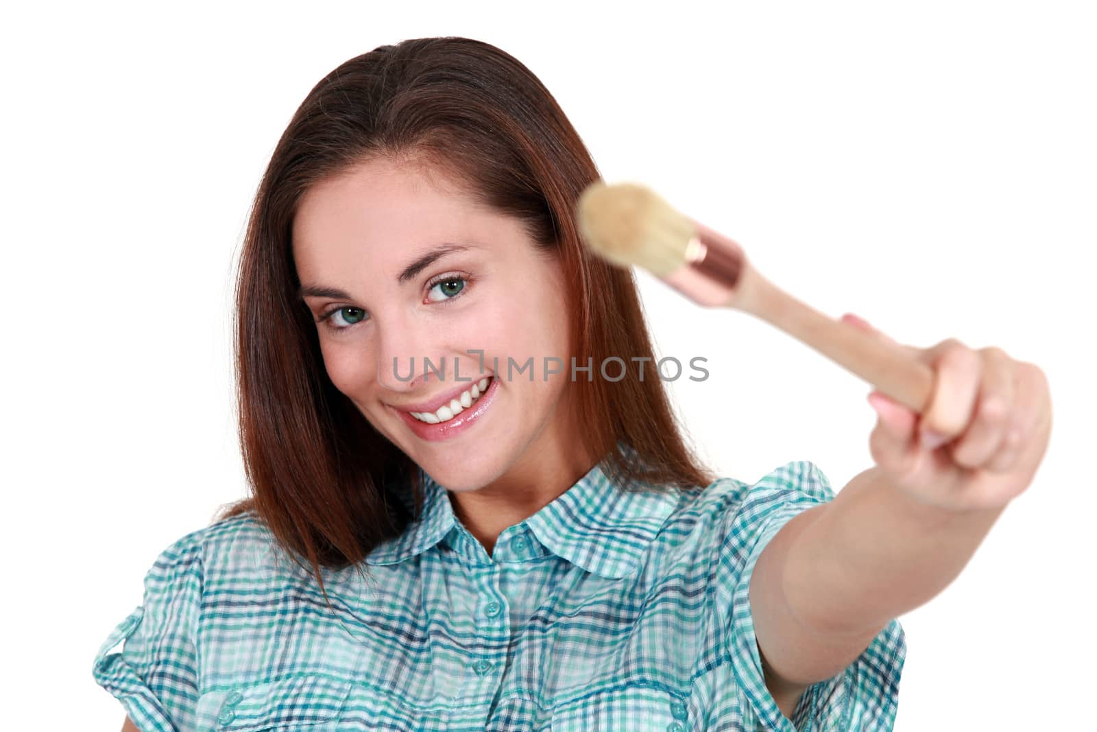 Pretty young woman showing a brush
