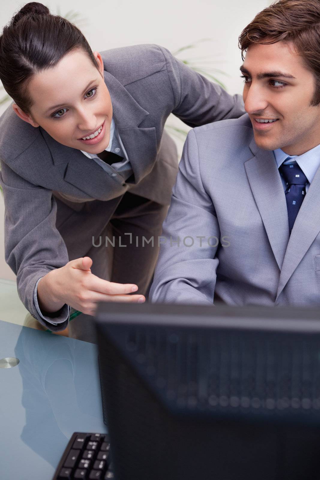 Colleagues in discussion while using computer at office by Wavebreakmedia