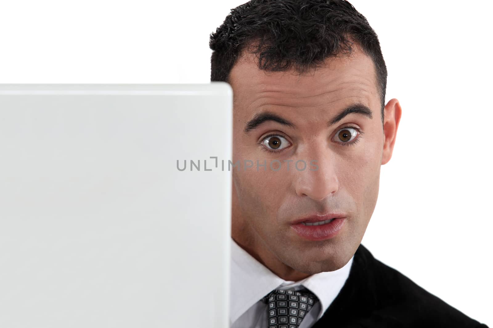 Surprised businessman at a laptop by phovoir