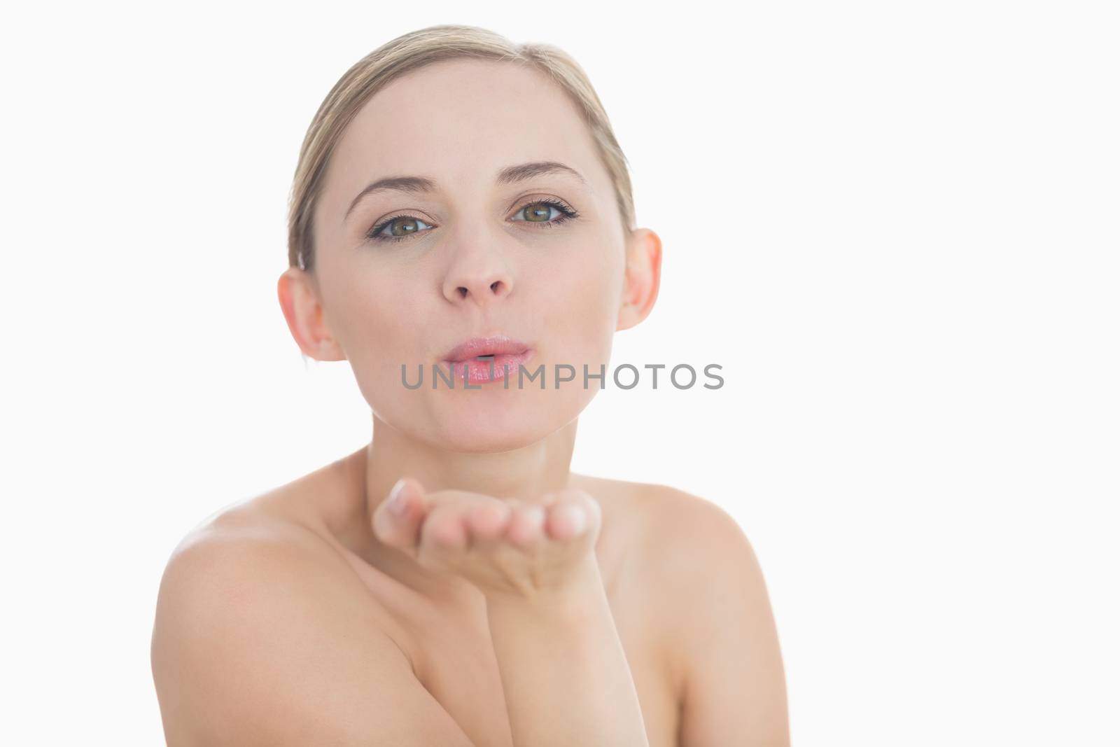 Closeup of cute young woman blowing a kiss over white background