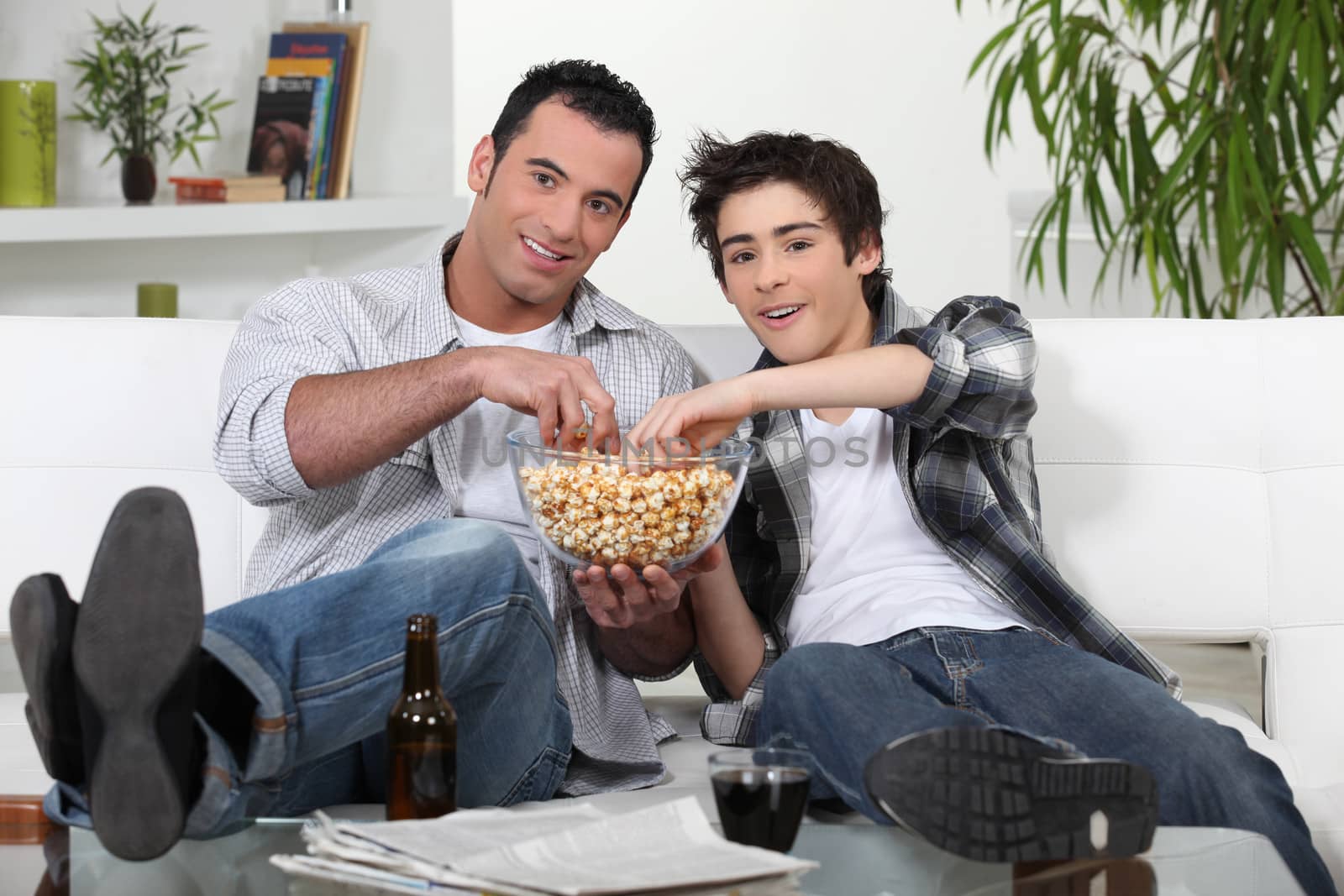 Father and son enjoying a movie by phovoir