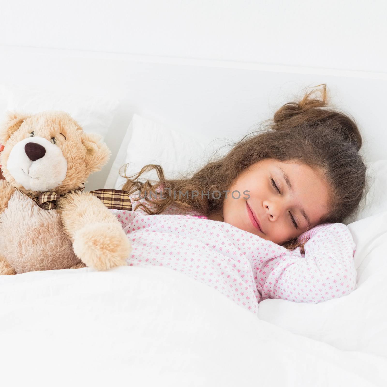 Little girl in bed sleeping with teddy bear