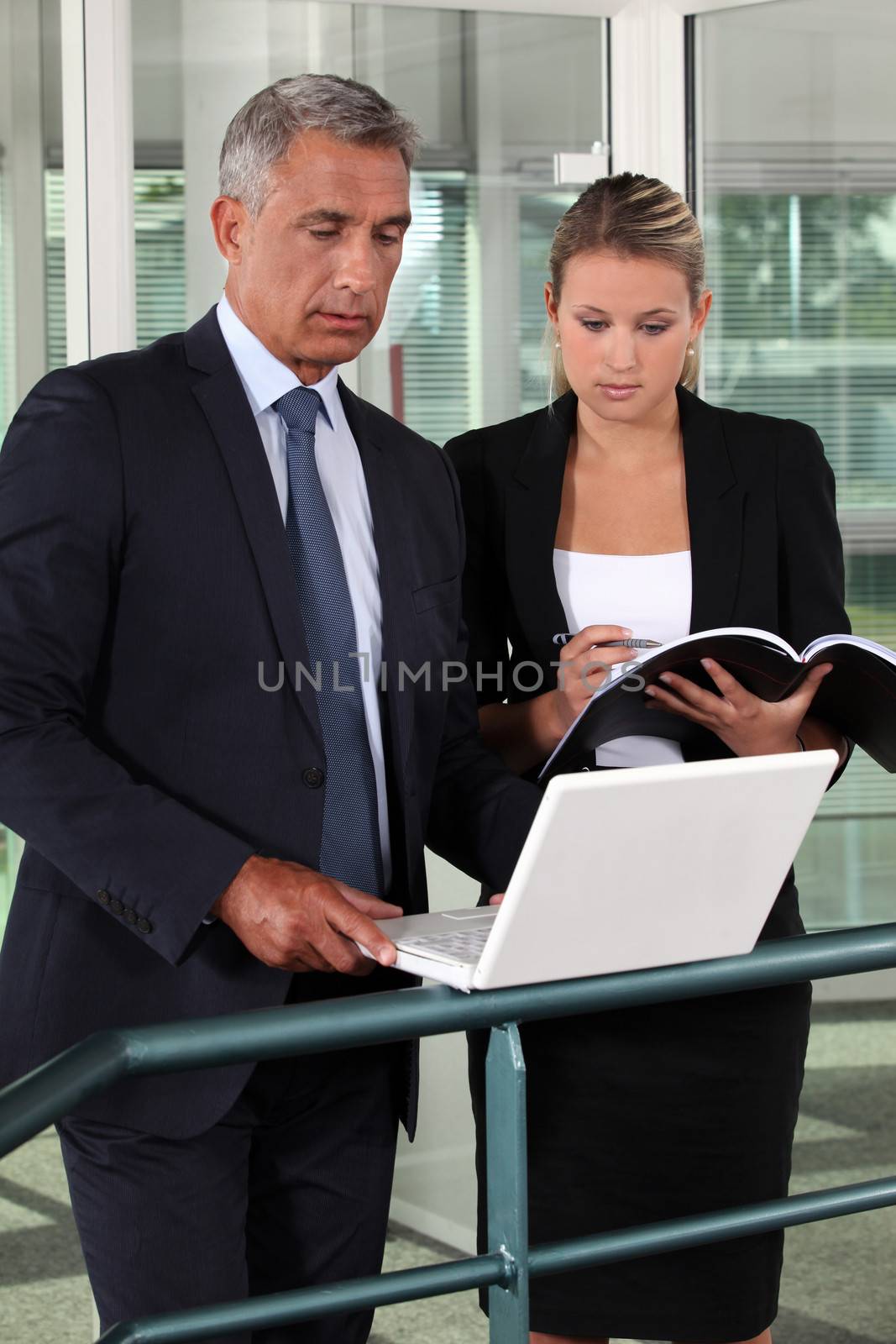 businessman and businesswoman verifying data