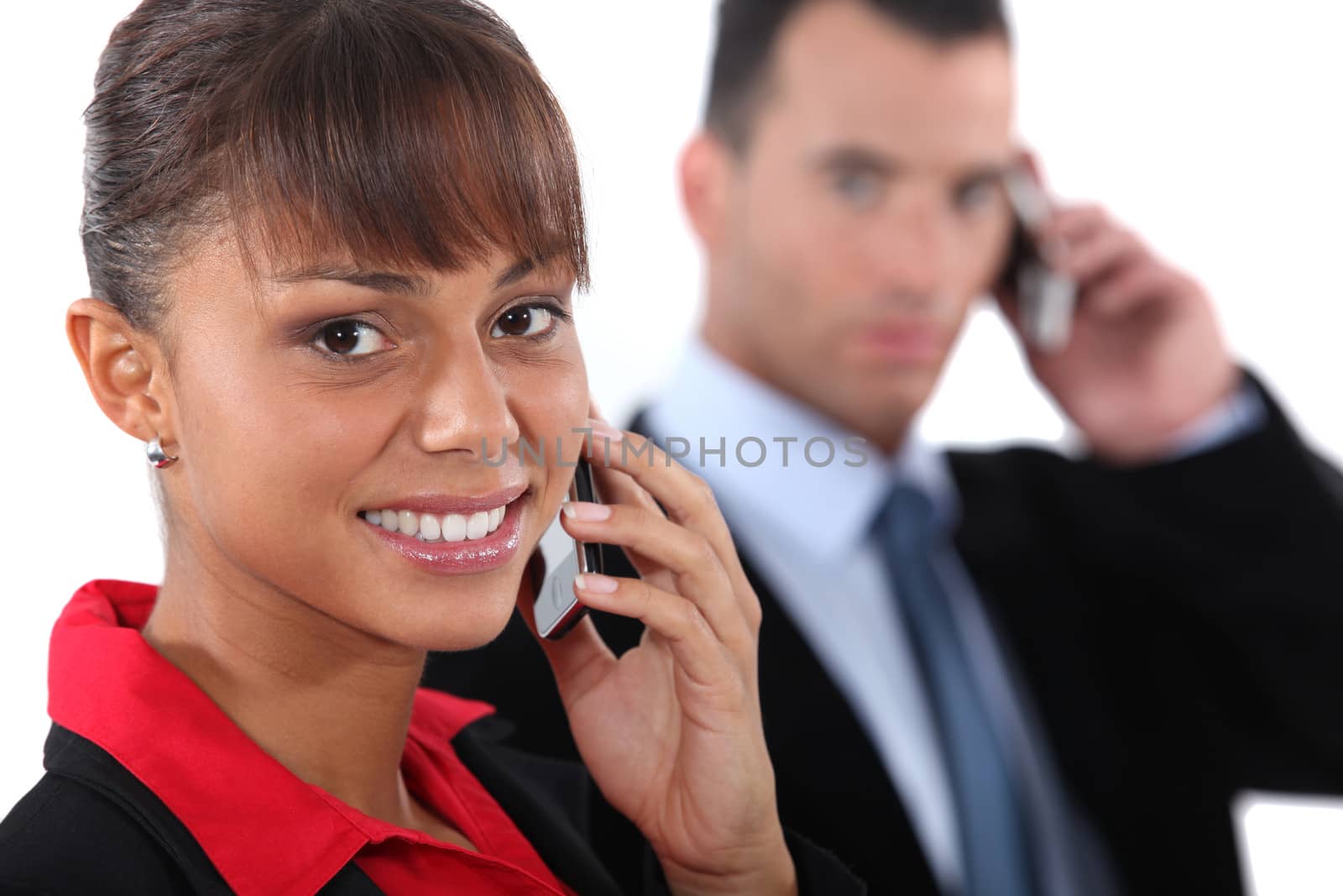 Businesspeople using cellphones by phovoir