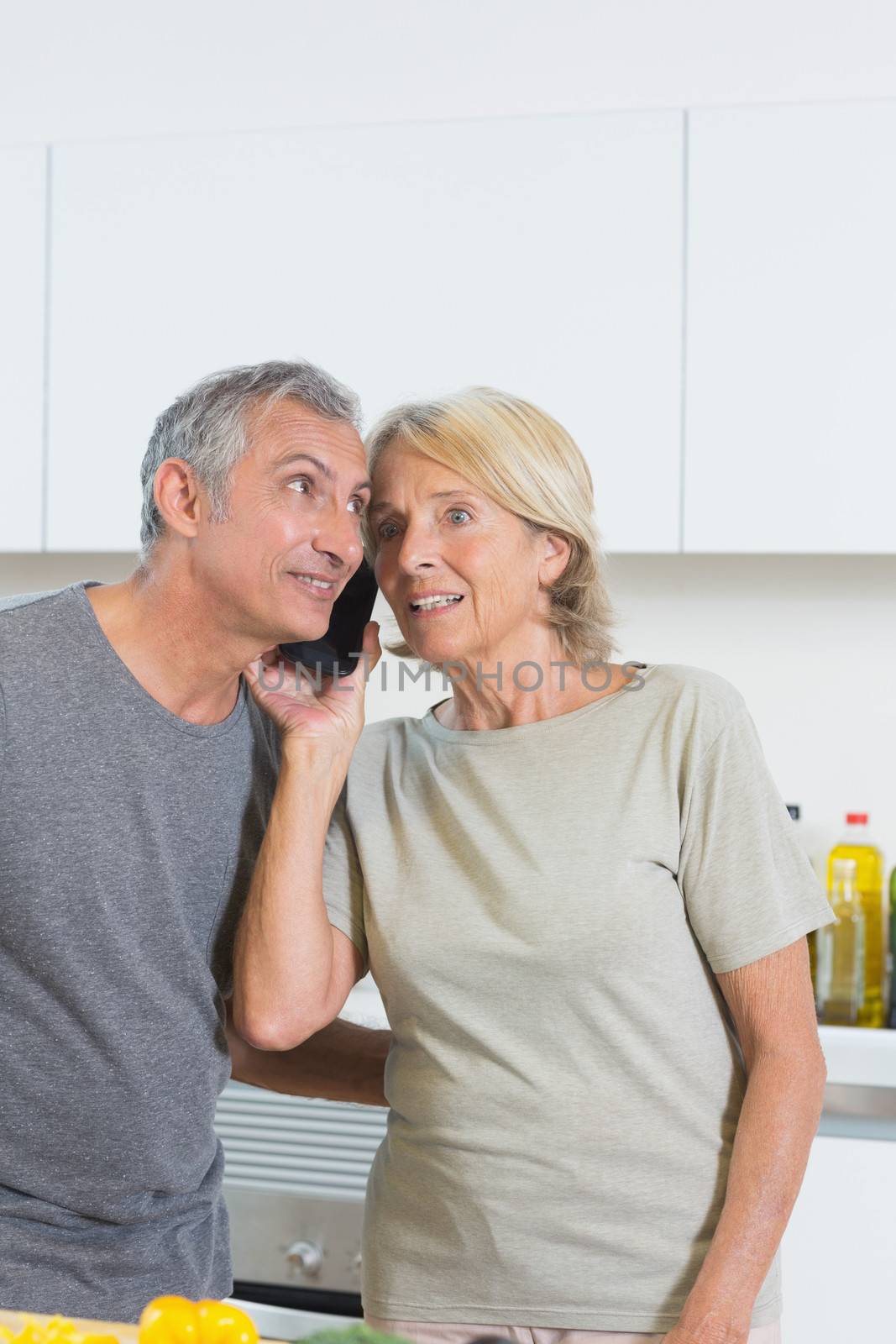 Mature couple listening a call together  by Wavebreakmedia