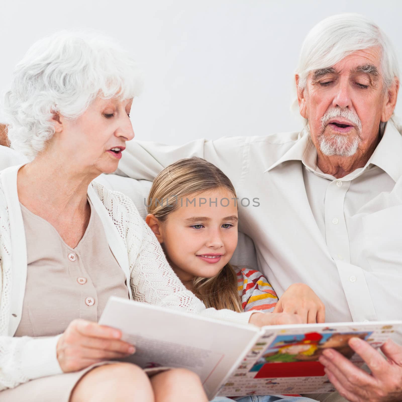 Little girl reading with grandparents by Wavebreakmedia