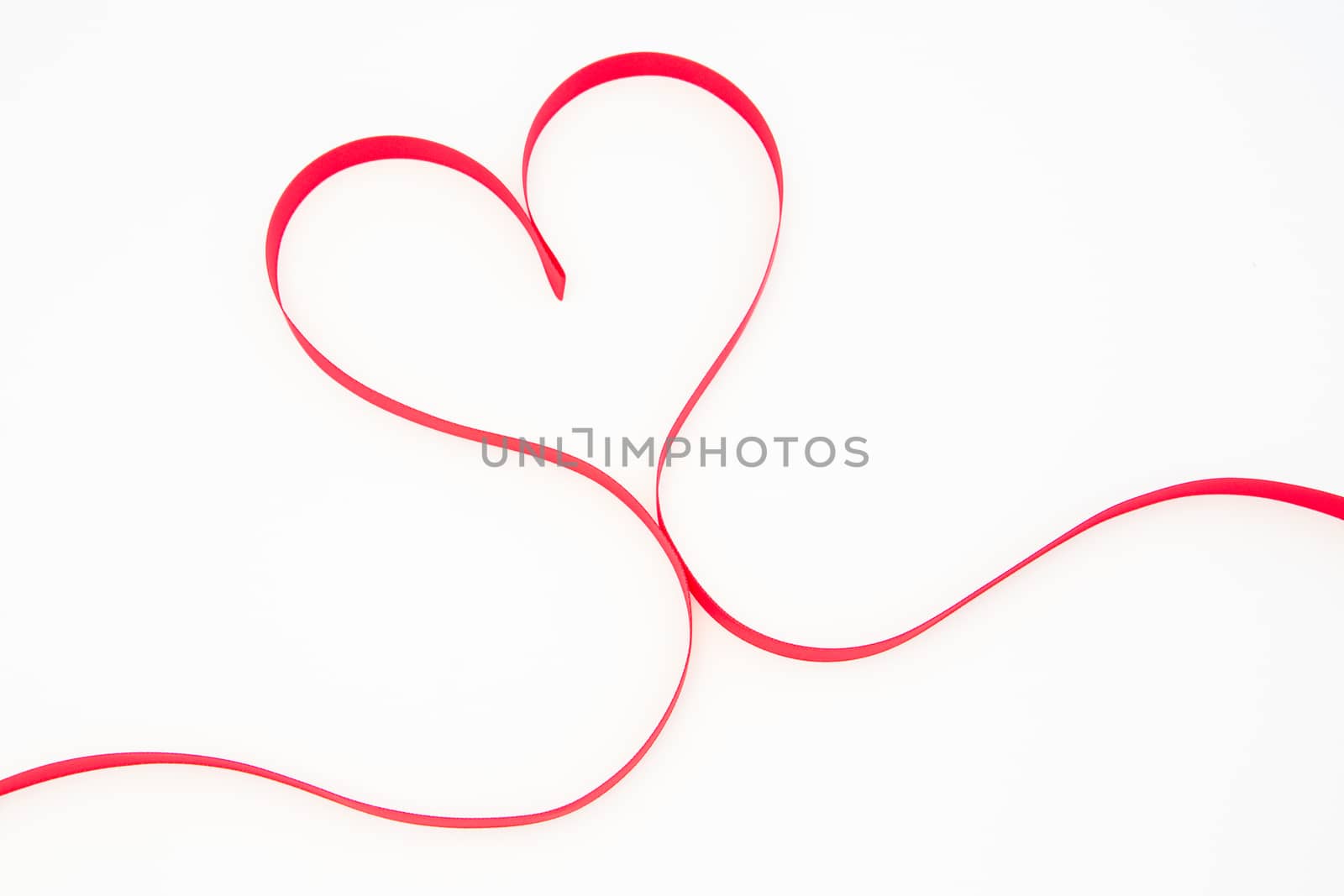 Heart shaped pink ribbon on white background
