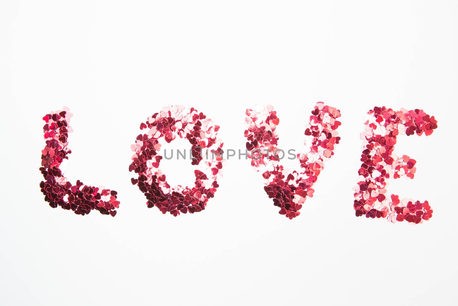 Pink confetti spelling out love on white background