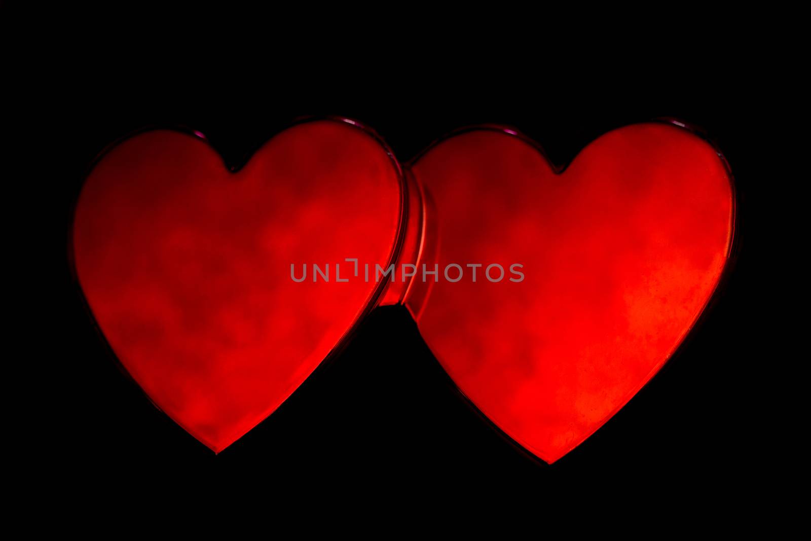 Red love hearts stuck together on black background