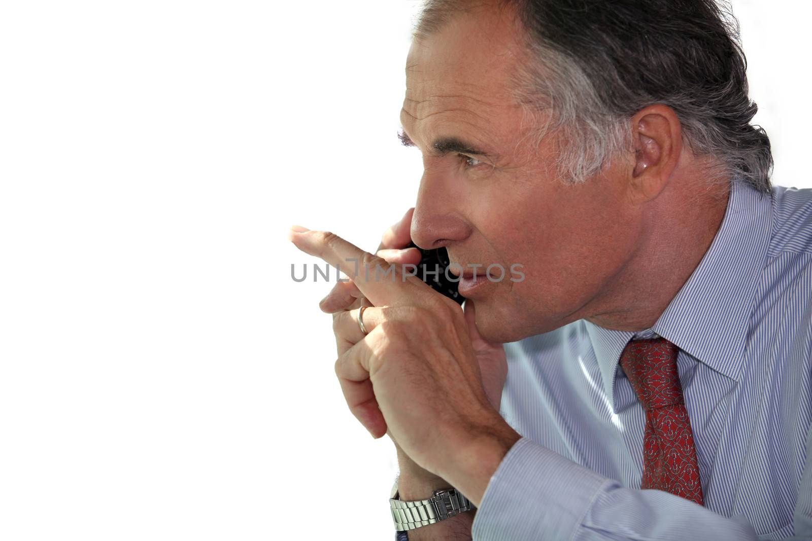 Businessman making hand gestures while talking on his mobile phone by phovoir