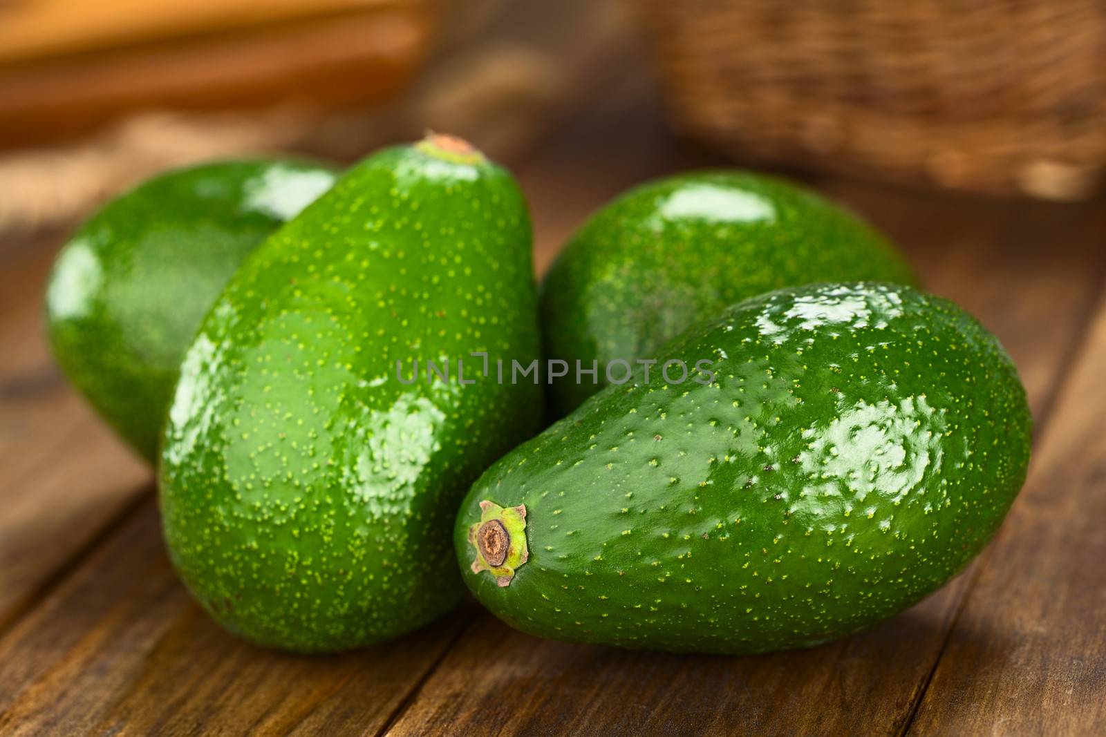 Four Avocados Fuerte on dark wood (Selective Focus, Focus on the front) 