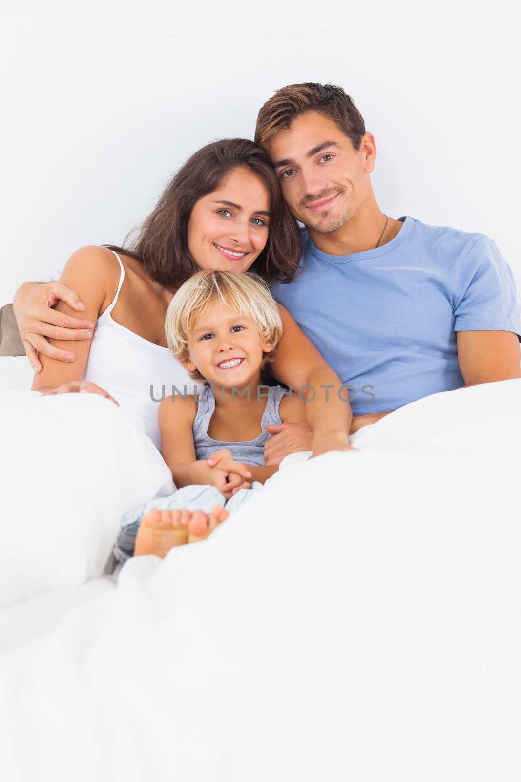 Lovely family embracing on the bed