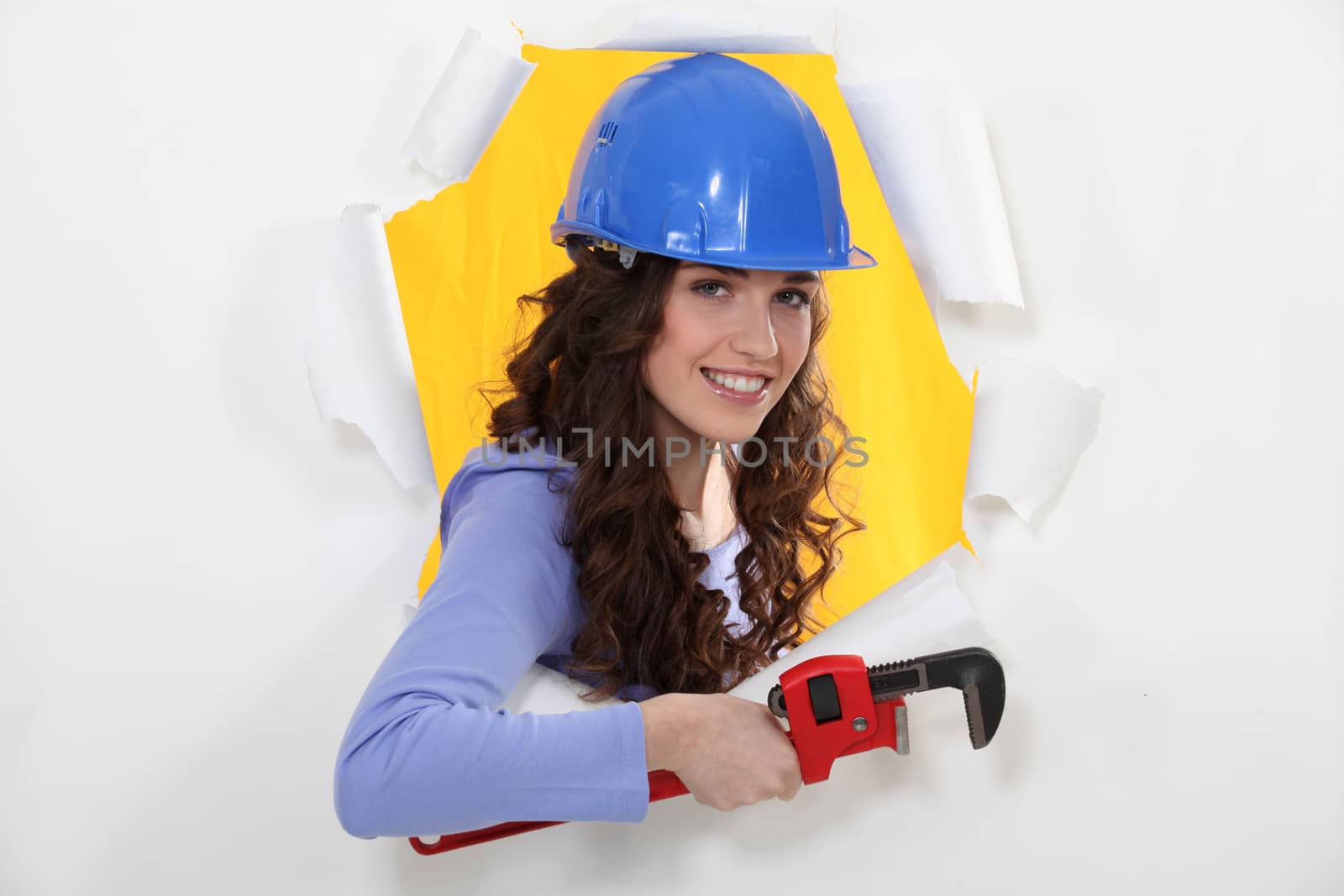 Female manual worker holding wrench by phovoir