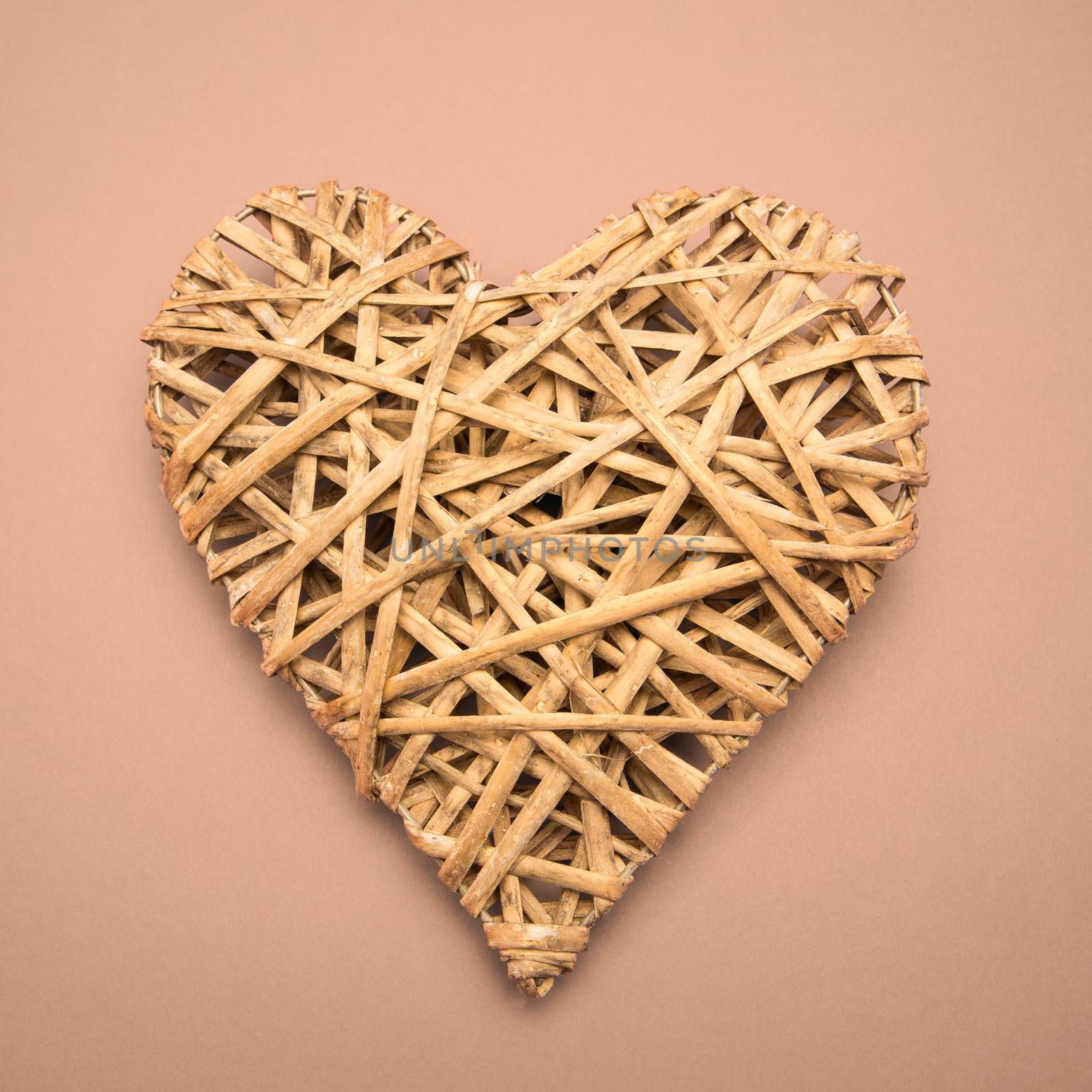 Wicker heart ornament on pink background
