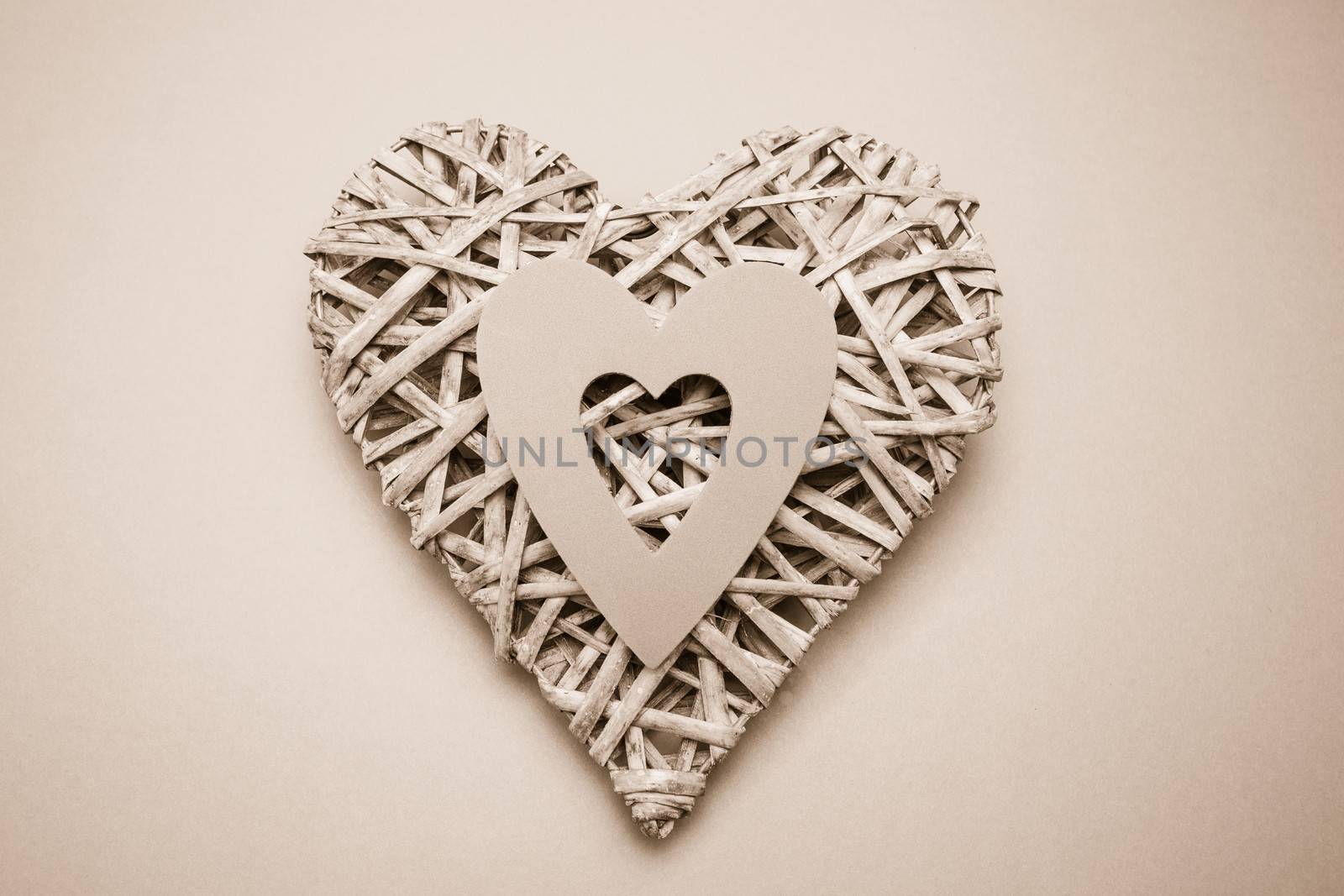 Wicker heart ornament with paper cut out on grey background