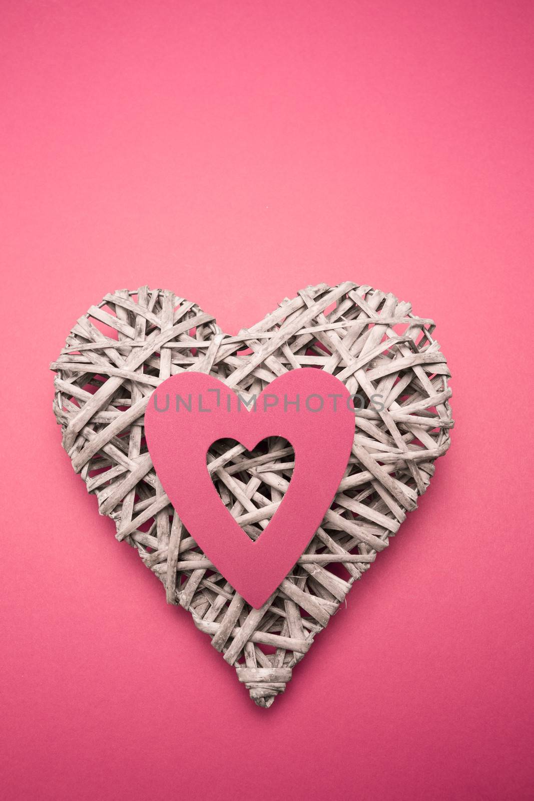 Wicker heart ornament with pink paper cut out by Wavebreakmedia