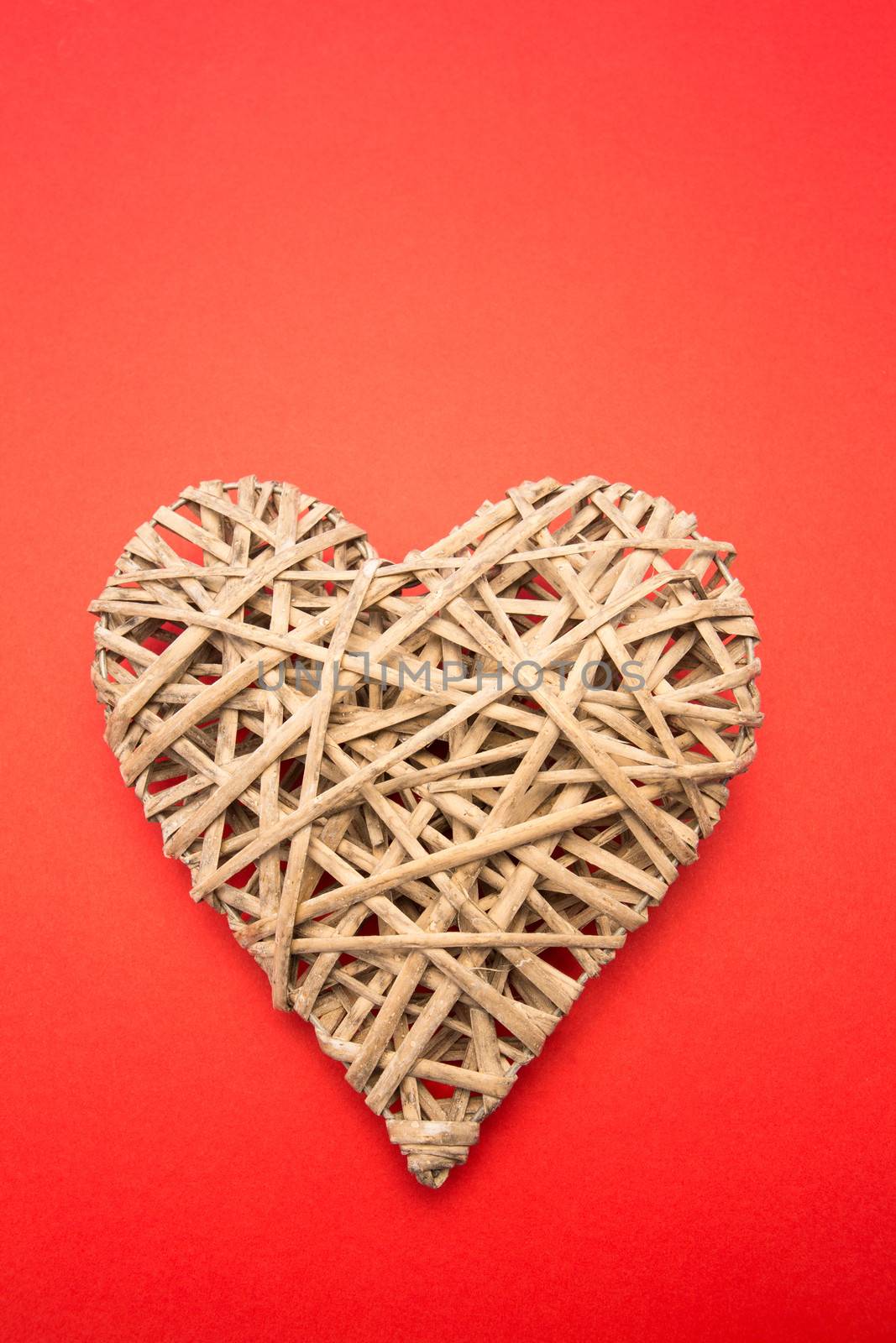 Wicker heart ornament on red background