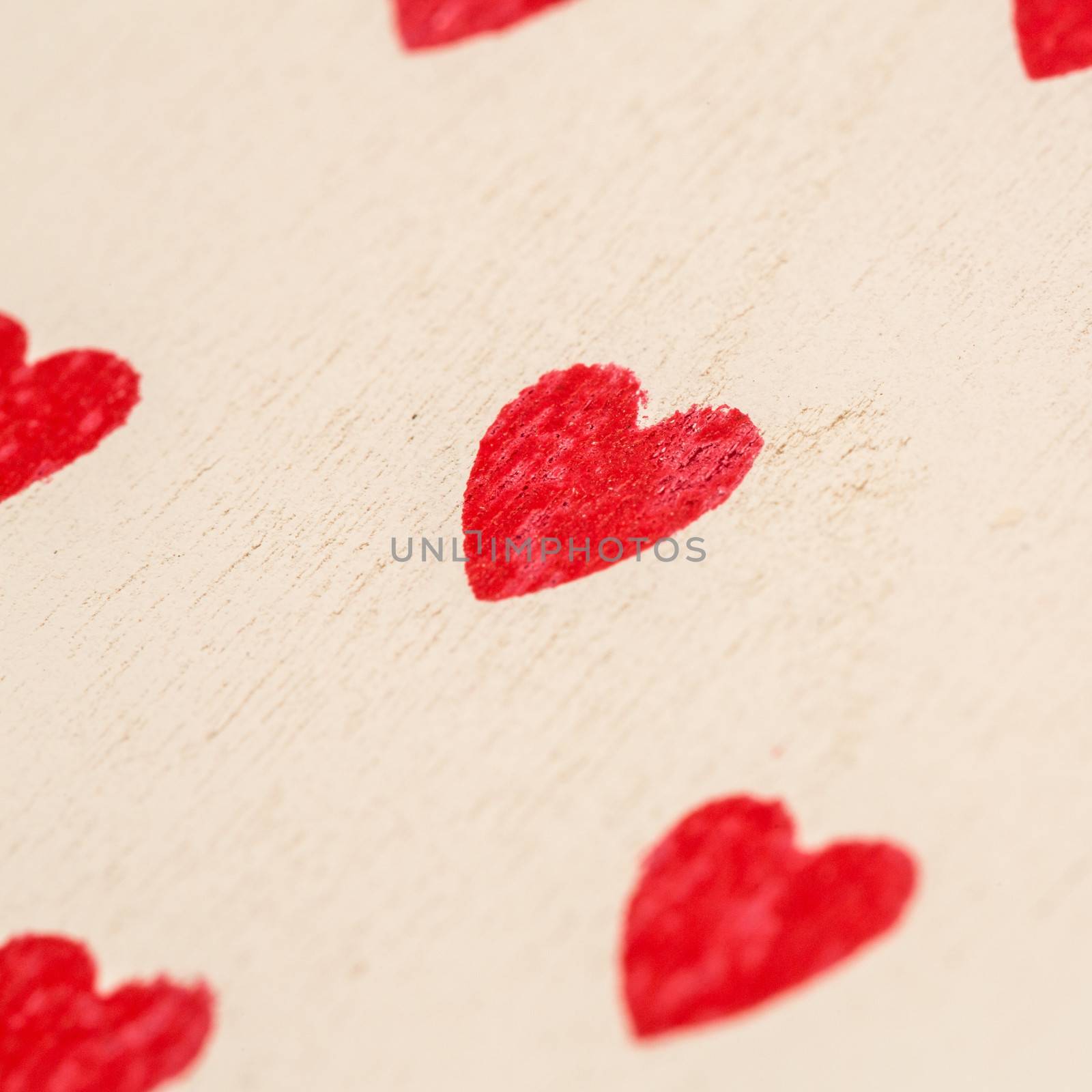 Red love hearts painted on pale wood
