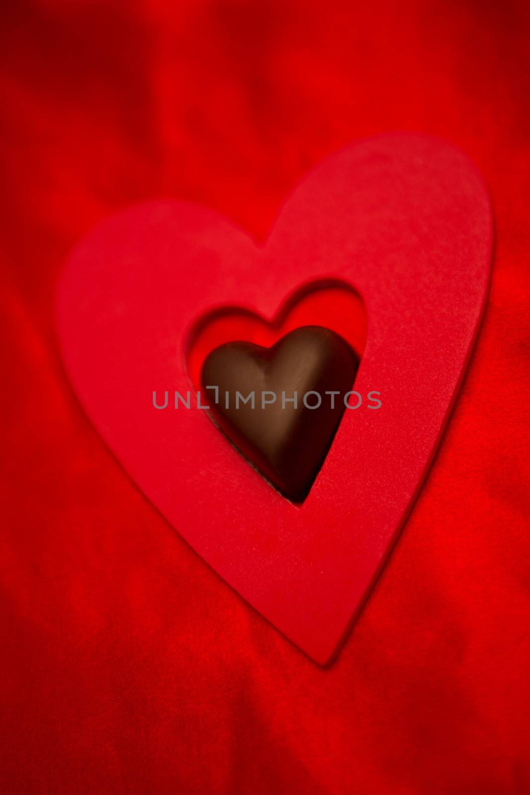 Chocolate love heart and red paper heart  by Wavebreakmedia