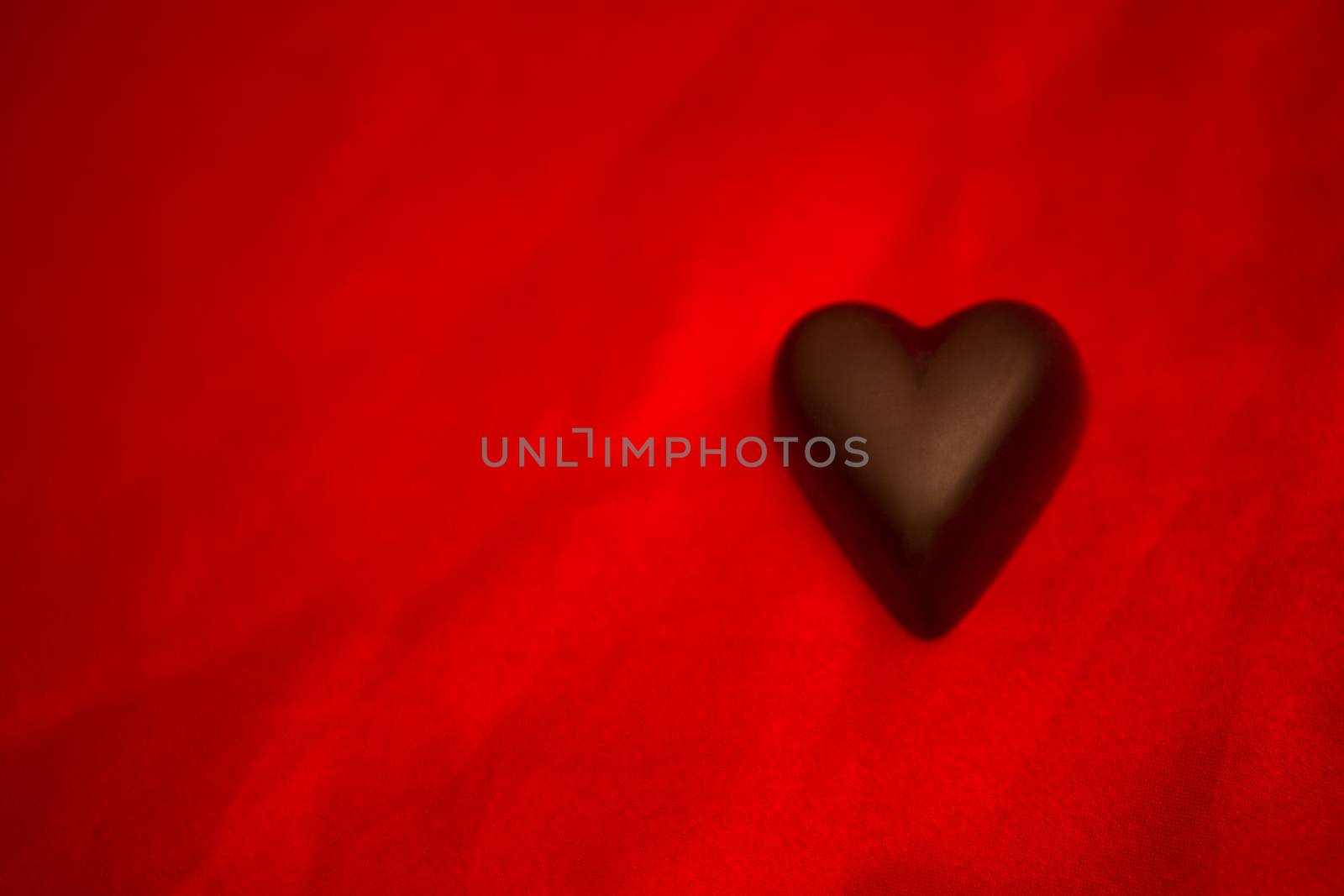 Chocolate heart on red silk