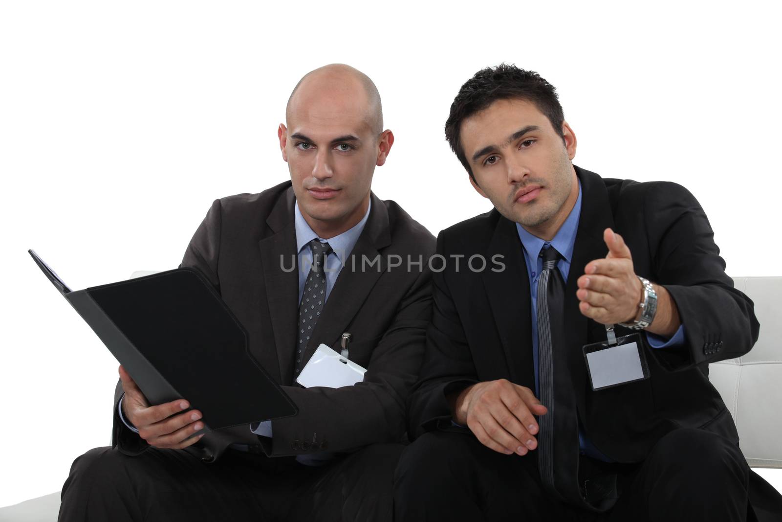two young businessmen sitting on a couch by phovoir