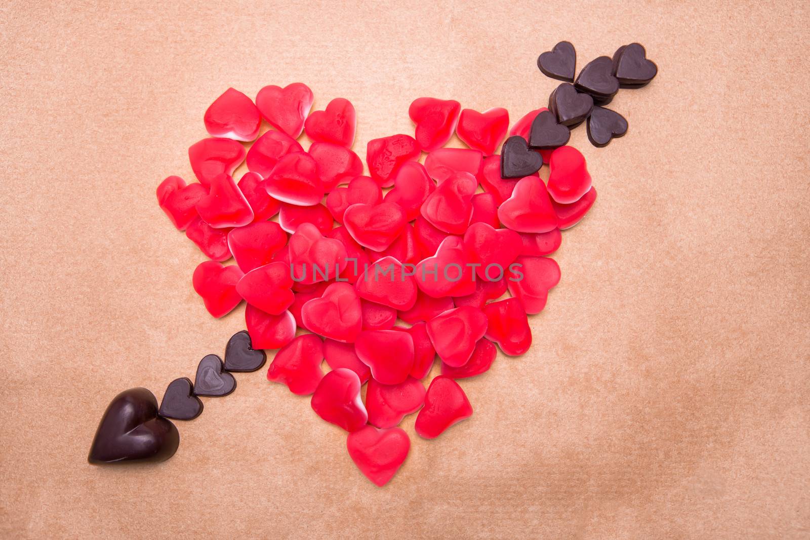 Heart and arrow shaped from heart shaped candy and chocolate
