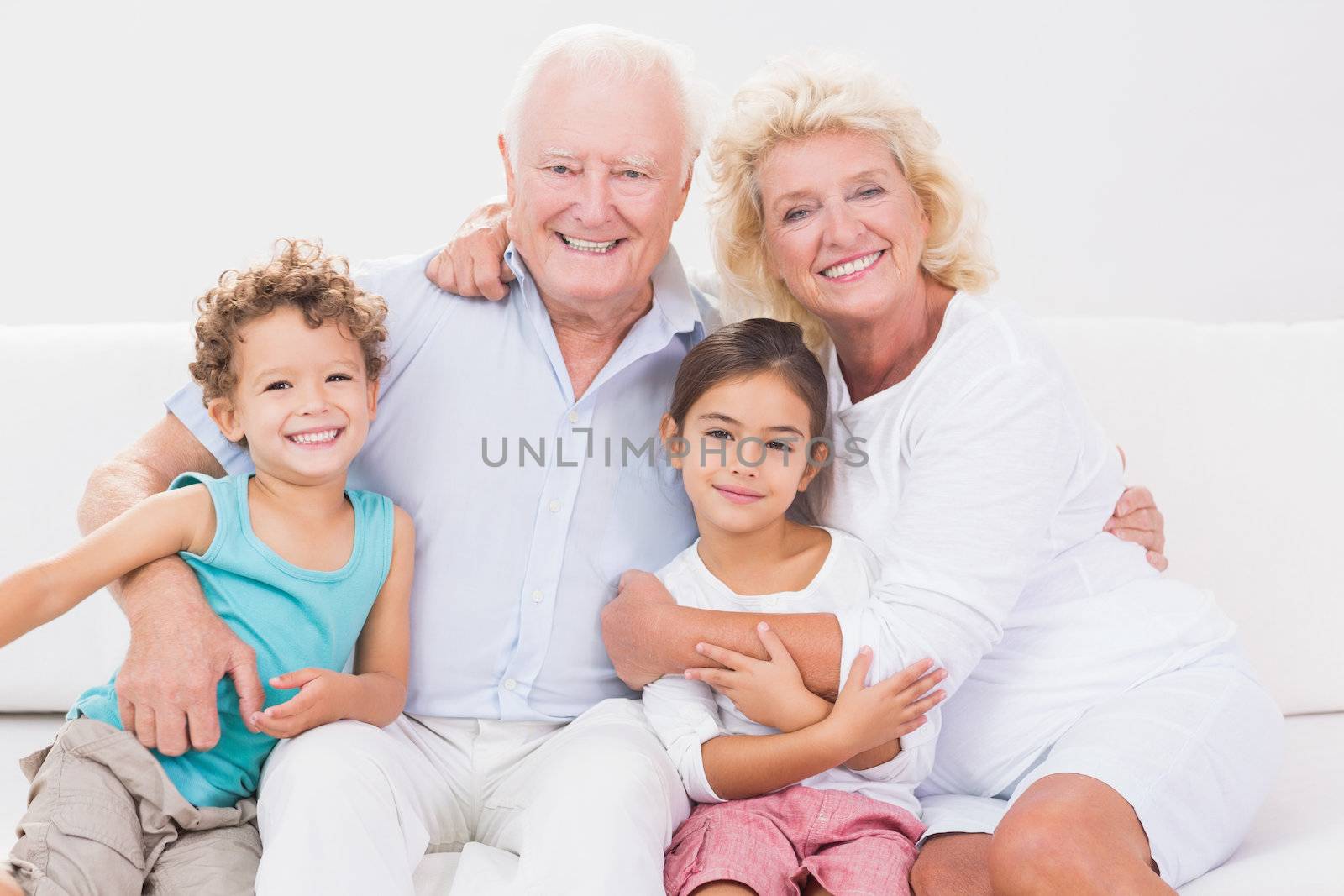Cheerful grandparents with children on a sofa