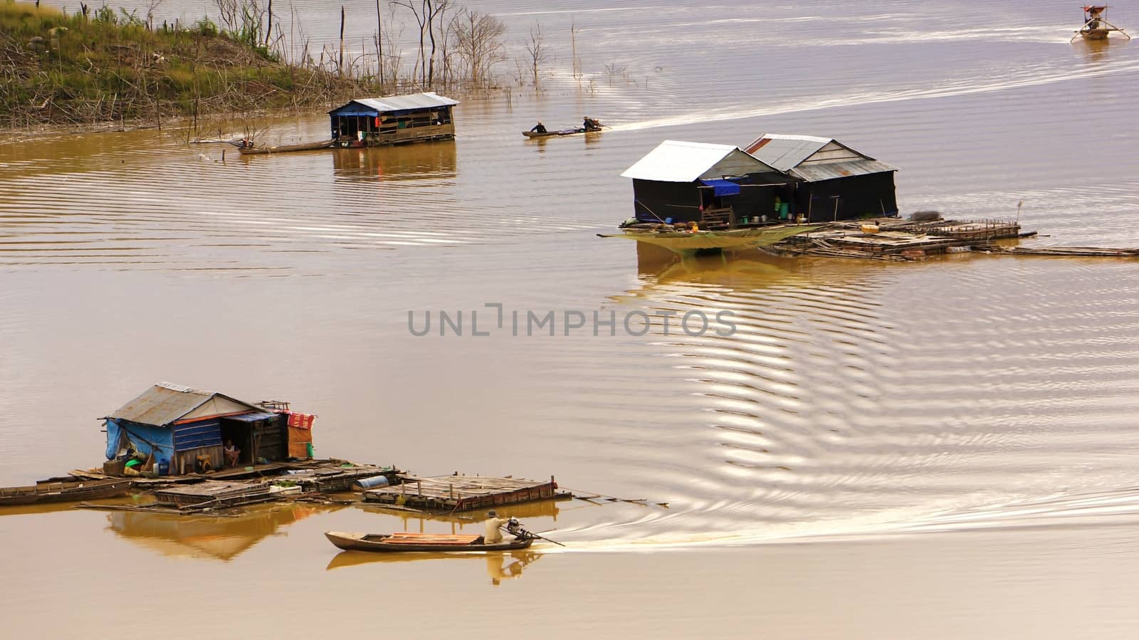 fisherman coming their lake dwelling by motor-boat at fishing vi by xuanhuongho