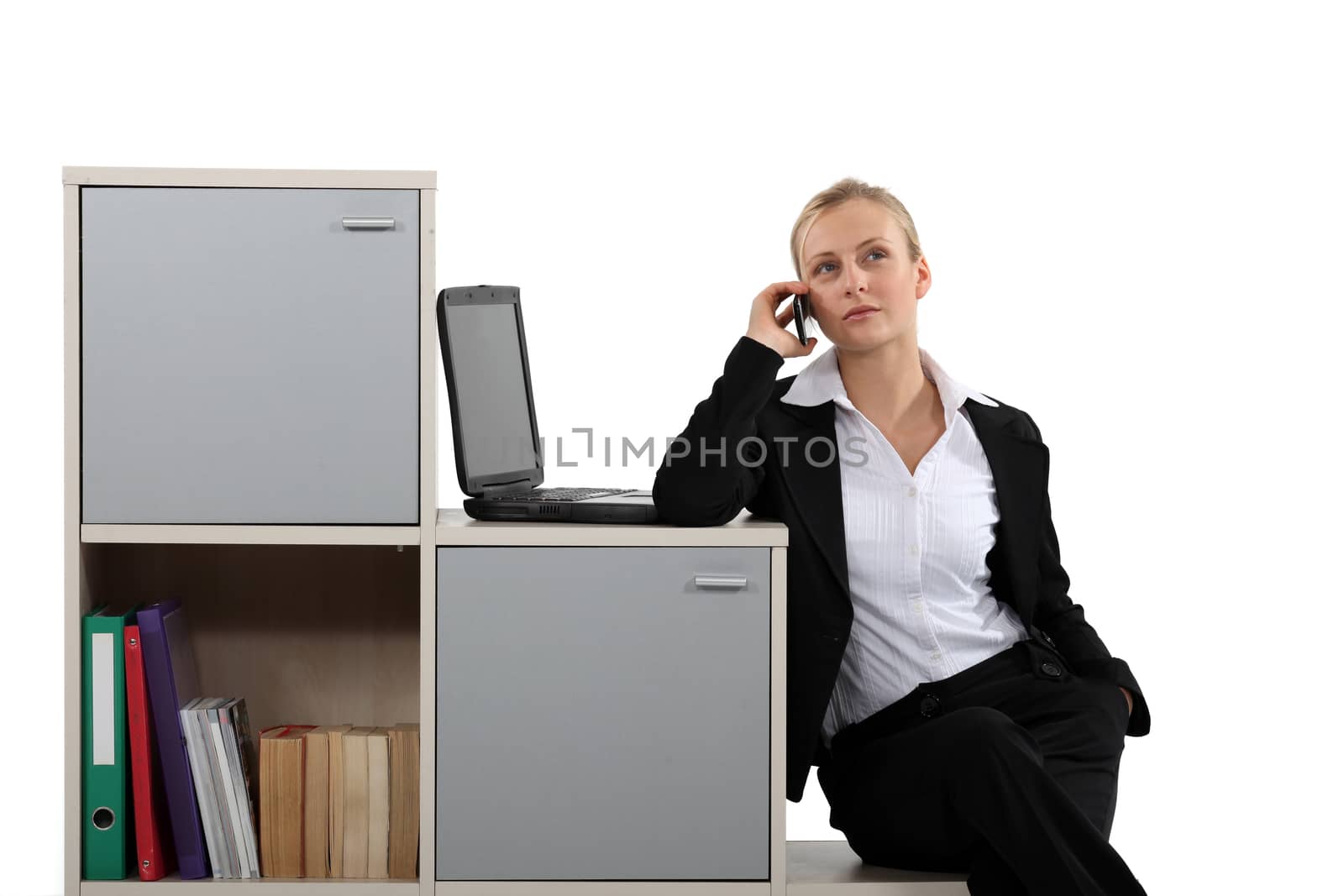 businesswoman working at home on the phone near laptop by phovoir